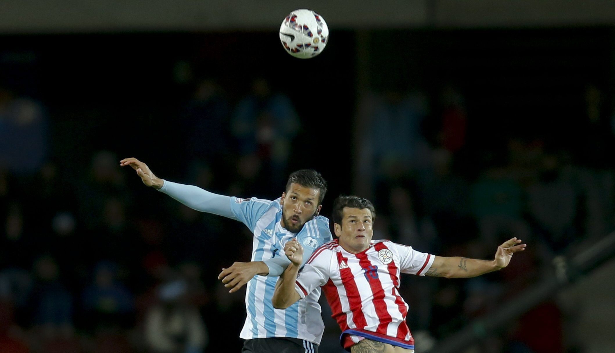 epaselect epa04798232 Argentina's Ezequiel Garay (L) fights for the ball with Paraguay's Nelson Valdez during the Copa America 2015 Group B soccer match between Argentina and Paraguay, at Estadio La Portada de La Serena in La Serena, Chile, 13 June 2015. EPA/JUAN CARLOS CARDENAS
