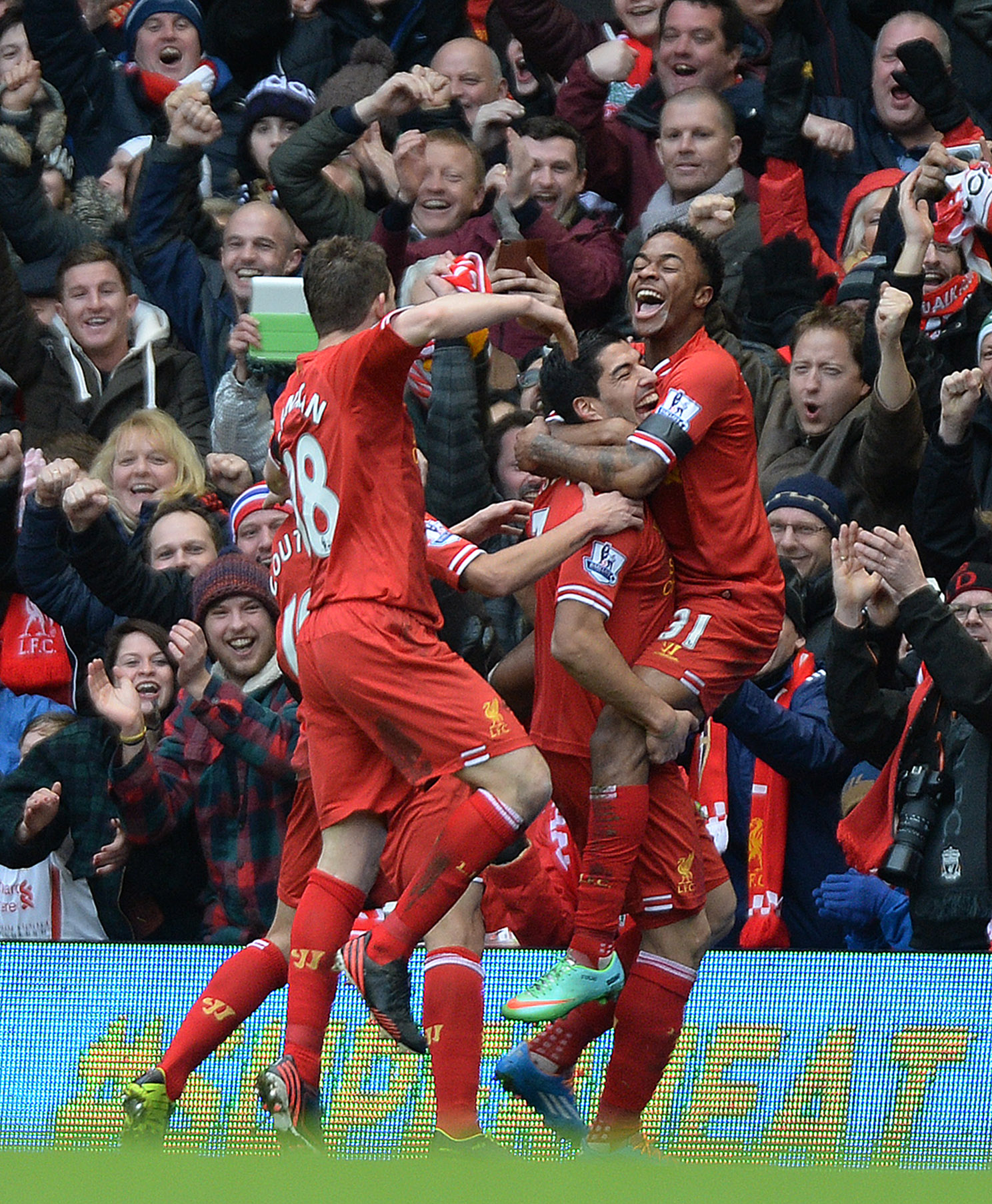 epa04061491 Liverpool's Raheem Sterling (R) is lifted in the air by team-mate Luis Suarez (C) in celebration after scoring the 3-0 goal during the English Premier League soccer match between Liverpool FC and Arsenal FC at Anfield Road stadium in Liverpool, Britain, 08 February 2014. EPA/PETER POWELL DataCo terms and conditions apply http://www.epa.eu/files/Terms%20and%20Conditions/DataCo_Terms_and_Conditions.pdf