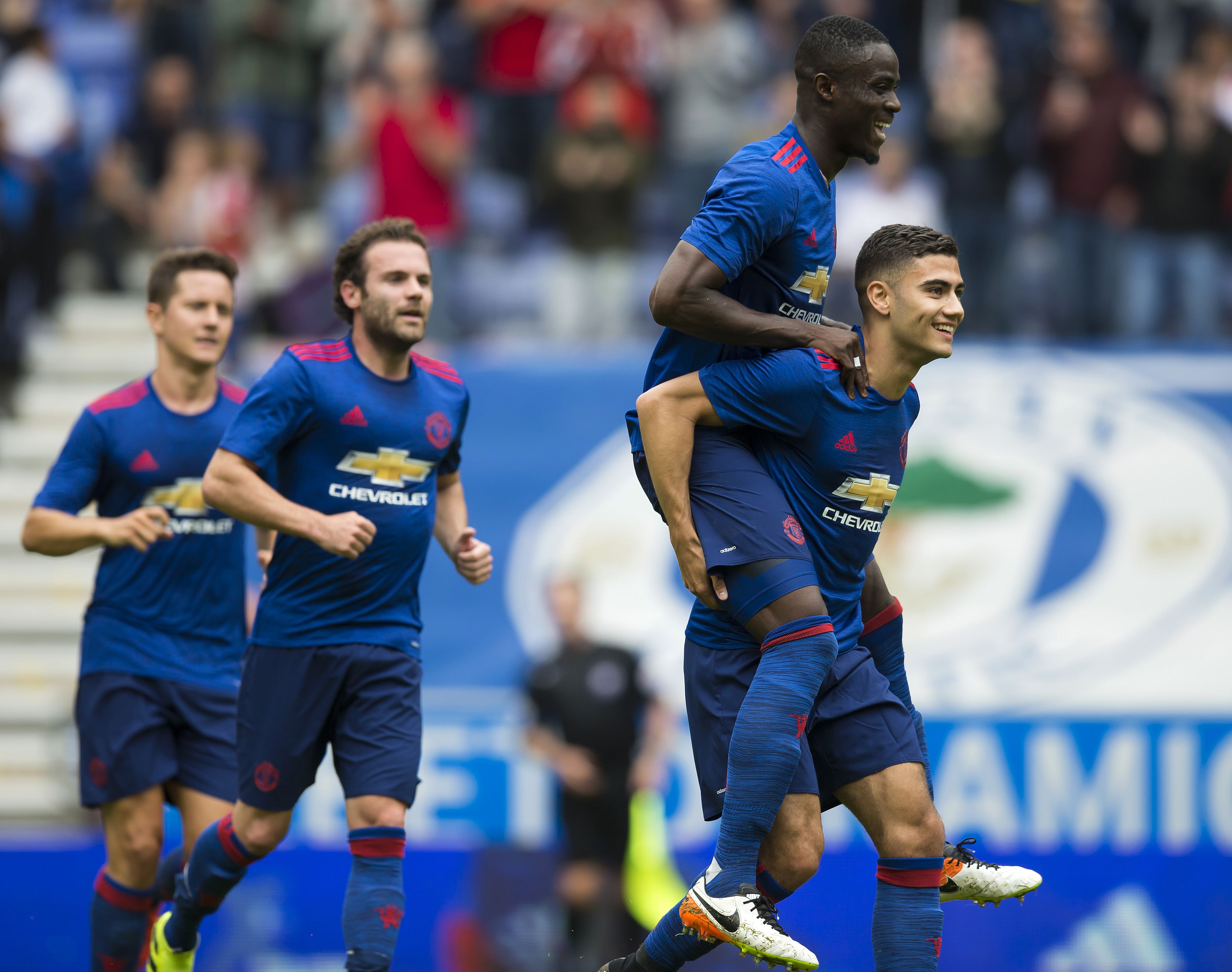 Manchester United's Belgian midfielder Andreas Pereira (R) celebrates with Manchester United's Ivorian midfielder Eric Bailly (2R) after scoring during the pre-season friendly football match between Wigan Athletic and Manchester United at the DW stadium in Wigan, northwest England, on July 16, 2016. / AFP / JON SUPER / RESTRICTED TO EDITORIAL USE. No use with unauthorized audio, video, data, fixture lists, club/league logos or 'live' services. Online in-match use limited to 75 images, no video emulation. No use in betting, games or single club/league/player publications. / (Photo credit should read JON SUPER/AFP/Getty Images)