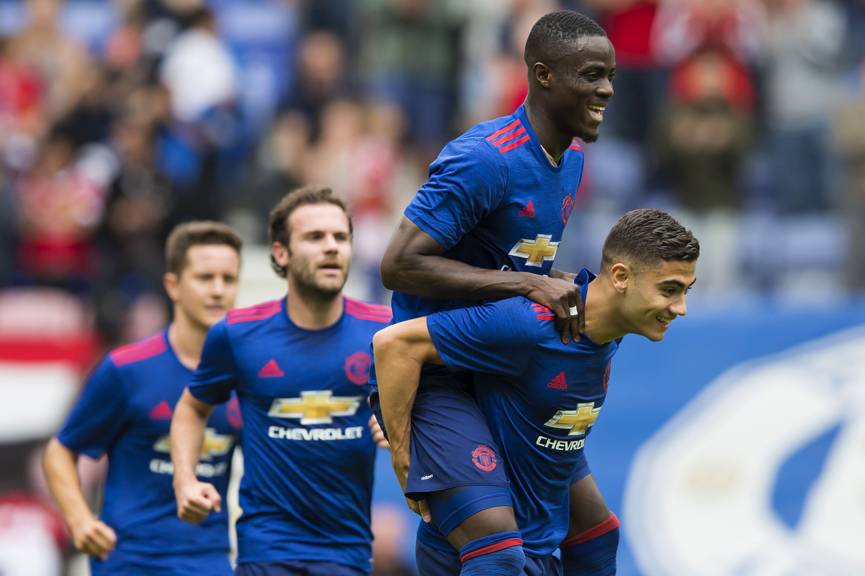 Manchester United's Belgian midfielder Andreas Pereira (R) celebrates with Manchester United's Ivorian midfielder Eric Bailly (2R) and Manchester United's Spanish midfielder Juan Mata (2L) after scoring during the pre-season friendly football match between Wigan Athletic and Manchester United at the DW stadium in Wigan, northwest England, on July 16, 2016. / AFP / JON SUPER / RESTRICTED TO EDITORIAL USE. No use with unauthorized audio, video, data, fixture lists, club/league logos or 'live' services. Online in-match use limited to 75 images, no video emulation. No use in betting, games or single club/league/player publications. / (Photo credit should read JON SUPER/AFP/Getty Images)