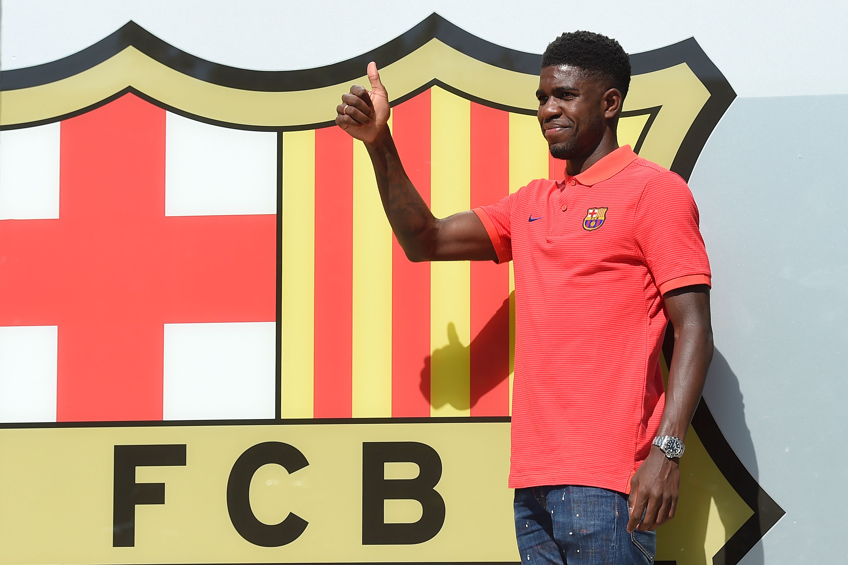 Barcelona's new player French defender Samuel Umtiti gives the thumbs up as he poses outside the Camp Nou stadium in Barcelona, prior to signing his new contract with the Catalan club, on July 14, 2016. / AFP / JOSEP LAGO (Photo credit should read JOSEP LAGO/AFP/Getty Images)