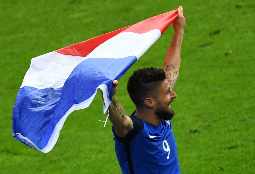 France's forward Olivier Giroud holds a French flag after winning the Euro 2016 quarter-final football match between France and Iceland at the Stade de France in Saint-Denis, near Paris, on July 3, 2016. / AFP / Francisco LEONG (Photo credit should read FRANCISCO LEONG/AFP/Getty Images)