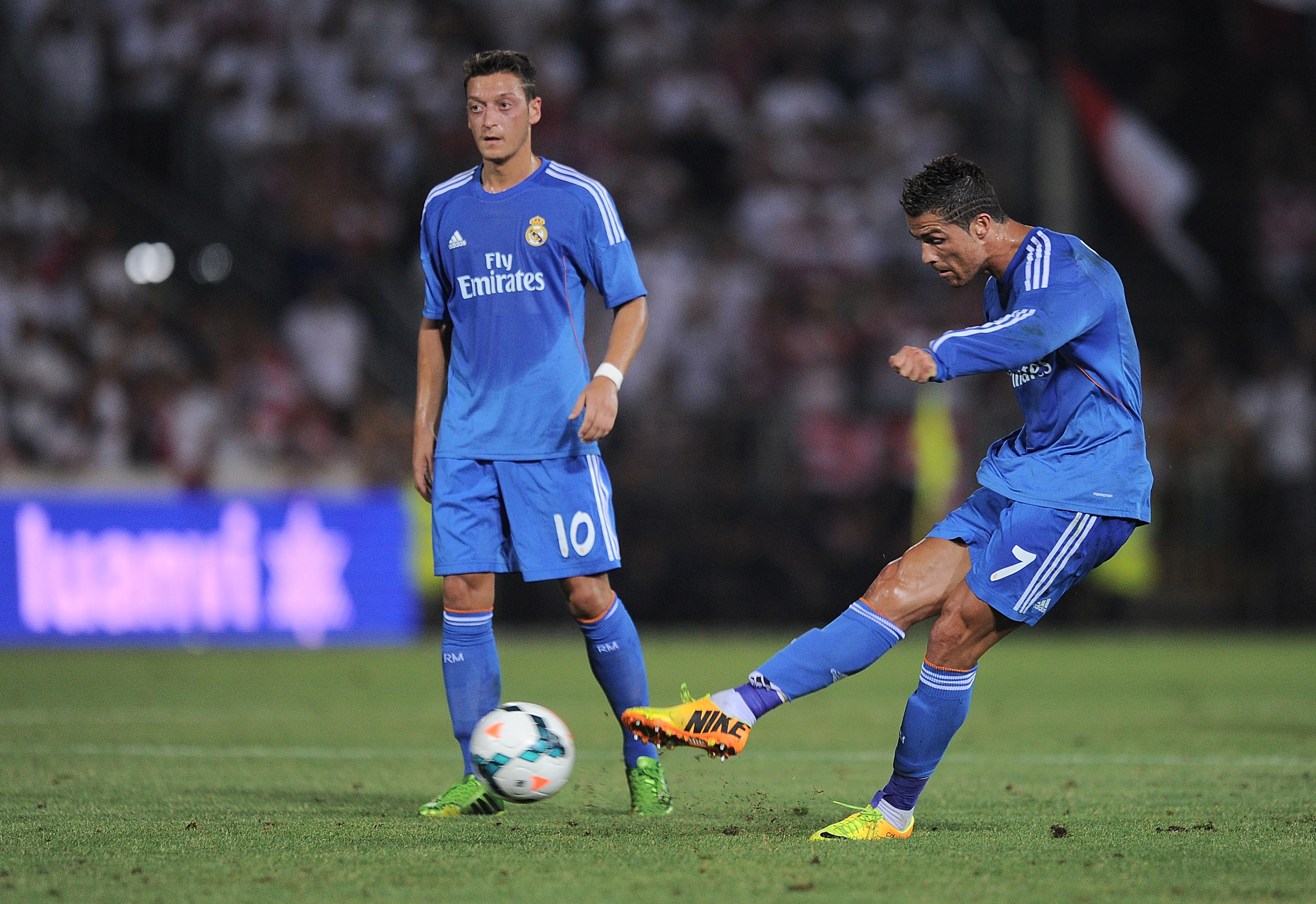 GRANADA, SPAIN - AUGUST 26: Cristiano Ronaldo (R) of Real Madrid CF takes a free kick beside Mesut Ozil during the La Liga match between Granada CF and Real Madrid CF at Estadio Nuevo Los Carmenes on August 26, 2013 in Granada, Spain. (Photo by Denis Doyle/Getty Images)