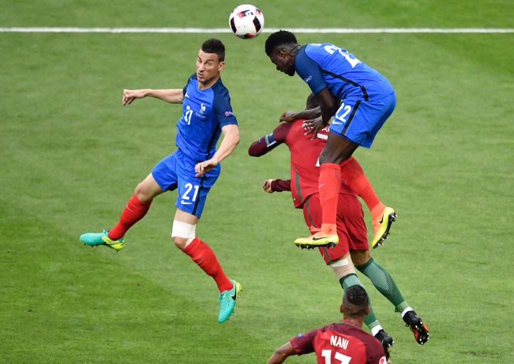 Portugal's forward Cristiano Ronaldo (hidden) vies for the ball with France's defender Laurent Koscielny (L) and France's defender Samuel Umtiti during the Euro 2016 final football match between Portugal and France at the Stade de France in Saint-Denis, north of Paris, on July 10, 2016. / AFP / PHILIPPE LOPEZ (Photo credit should read PHILIPPE LOPEZ/AFP/Getty Images)