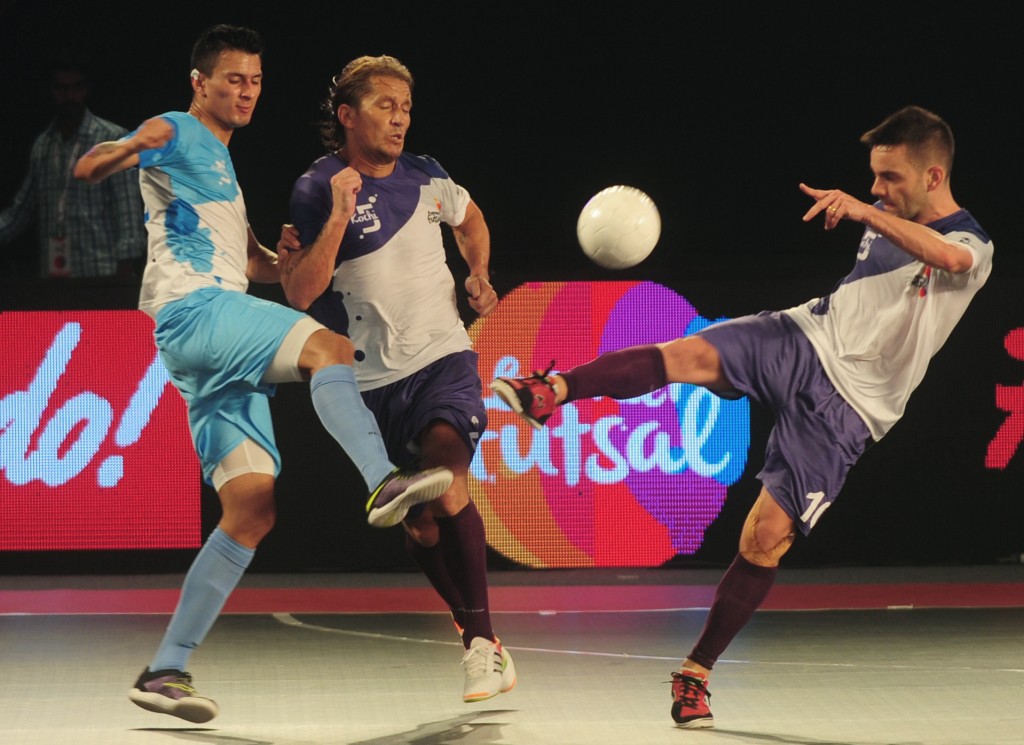 Kochi's Deives Moraes (R) and Miguel Salgado (C) play against Mumbai 5's Angellot during their Premier Futsal Football League match in Chennai on July 16, 2016. / AFP / ARUN SANKAR (Photo credit should read ARUN SANKAR/AFP/Getty Images)