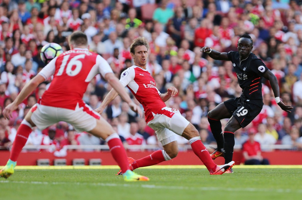 Liverpool's Senegalese midfielder Sadio Mane (R) scores Liverpool's fourth goal during the English Premier League football match between Arsenal and Liverpool at the Emirates Stadium in London on August 14, 2016. / AFP / Lee MILLS / RESTRICTED TO EDITORIAL USE. No use with unauthorized audio, video, data, fixture lists, club/league logos or 'live' services. Online in-match use limited to 75 images, no video emulation. No use in betting, games or single club/league/player publications. / (Photo credit should read LEE MILLS/AFP/Getty Images)