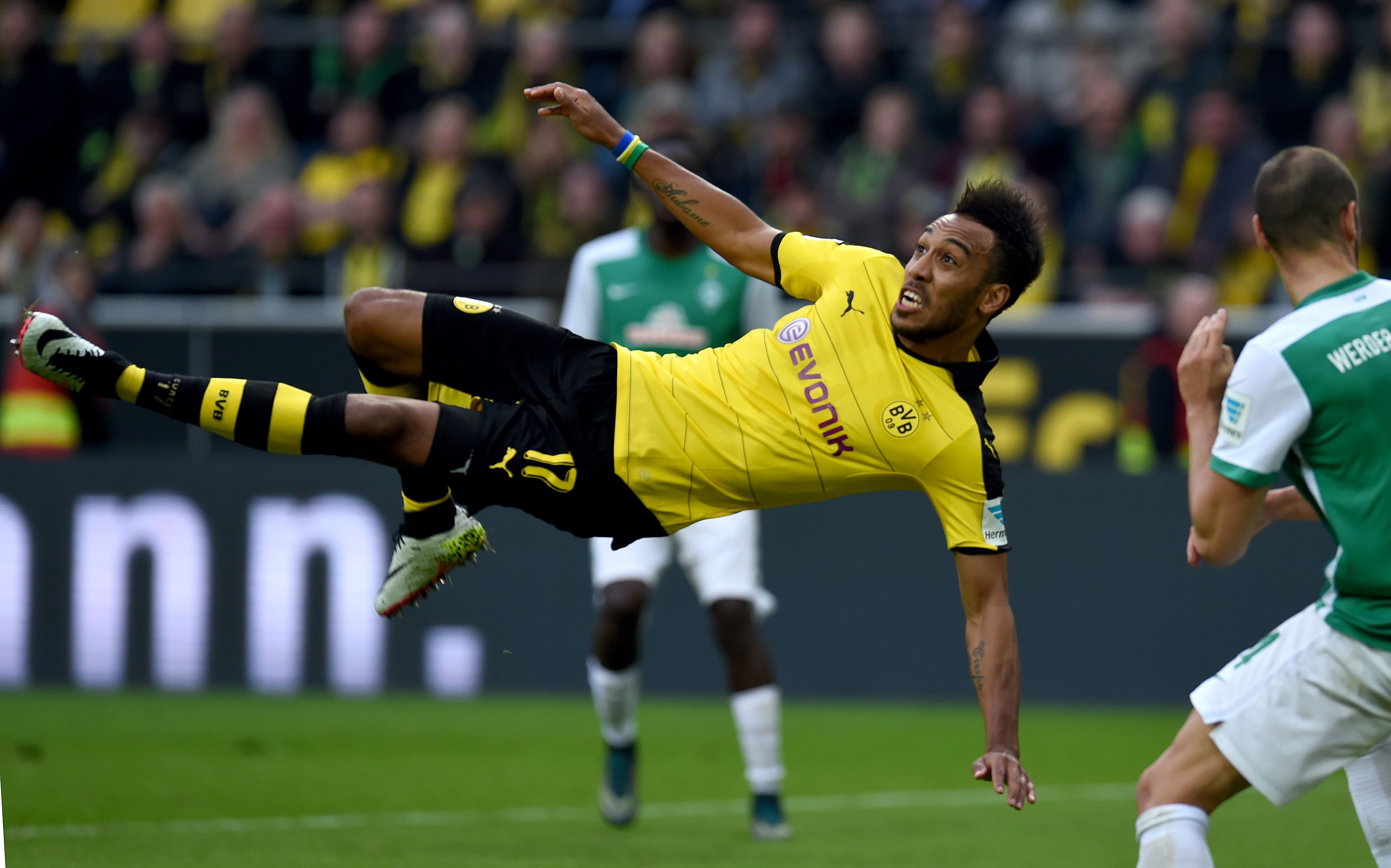 Dortmund's Gabonese striker Pierre-Emerick Aubameyang falls on the pitch as he plays the ball during the German Bundesliga first division football match between Borussia Dortmund and Werder Bremen in Dortmund, western Germany, on April 2, 2016. / AFP / PATRIK STOLLARZ / RESTRICTIONS: DURING MATCH TIME: DFL RULES TO LIMIT THE ONLINE USAGE TO 15 PICTURES PER MATCH AND FORBID IMAGE SEQUENCES TO SIMULATE VIDEO. == RESTRICTED TO EDITORIAL USE == FOR FURTHER QUERIES PLEASE CONTACT DFL DIRECTLY AT + 49 69 650050 (Photo credit should read PATRIK STOLLARZ/AFP/Getty Images)