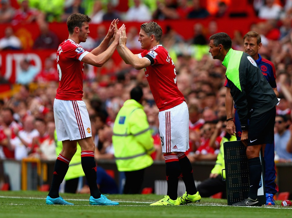 MANCHESTER, ENGLAND - AUGUST 08: Bastian Schweinsteiger of Manchester United high fives with his team mate Michael Carrick during the Barclays Premier League match between Manchester United and Tottenham Hotspur at Old Trafford on August 8, 2015 in Manchester, England. (Photo by Clive Brunskill/Getty Images)