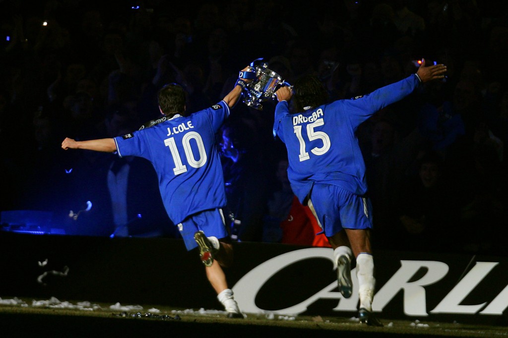 Chelsea's Joe Cole (L) and Didier Drogba run with the Carling Cup trophy after defeating Liverpool in the Carling Cup Final football match at the Millennium Dome in Cardiff, Wales, 27 February, 2005. Chelsea won 3-2 in extra time. AFP PHOTO/JIM WATSON NO TELCOS, WEBSITES SUBJECT TO SUBCRIPTION OF LICENCE WITH FAPL AT WWW.FAPLWEB.COM (Photo credit should read JIM WATSON/AFP/Getty Images)