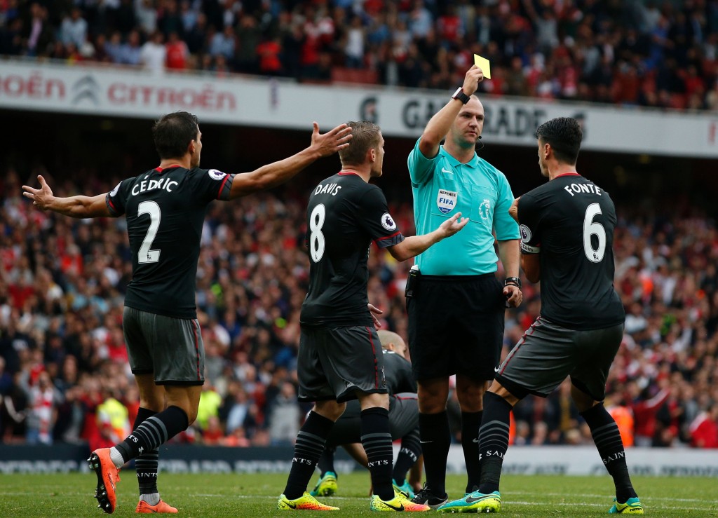 Referee Robert Madley shows a yellow card to Southampton's Portuguese defender Jose Fonte as he gives away a late penalty during the English Premier League football match between Arsenal and Southampton at the Emirates Stadium in London on September 10, 2016. Arsenal won the game 2-1. / AFP / Adrian DENNIS / RESTRICTED TO EDITORIAL USE. No use with unauthorized audio, video, data, fixture lists, club/league logos or 'live' services. Online in-match use limited to 75 images, no video emulation. No use in betting, games or single club/league/player publications. / (Photo credit should read ADRIAN DENNIS/AFP/Getty Images)