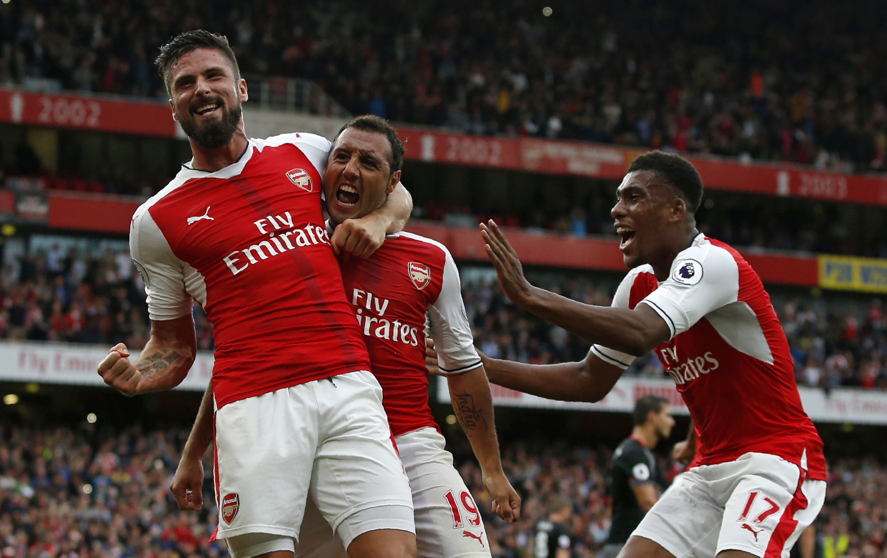 Arsenal's Spanish midfielder Santi Cazorla (C) celebrates with Arsenal's French striker Olivier Giroud and Arsenal's Nigerian striker Alex Iwobi (R) after scoring the winning goal from the penalty spot during the English Premier League football match between Arsenal and Southampton at the Emirates Stadium in London on September 10, 2016.
Arsenal won the game 2-1. / AFP / Adrian DENNIS / RESTRICTED TO EDITORIAL USE. No use with unauthorized audio, video, data, fixture lists, club/league logos or 'live' services. Online in-match use limited to 75 images, no video emulation. No use in betting, games or single club/league/player publications. / (Photo credit should read ADRIAN DENNIS/AFP/Getty Images)