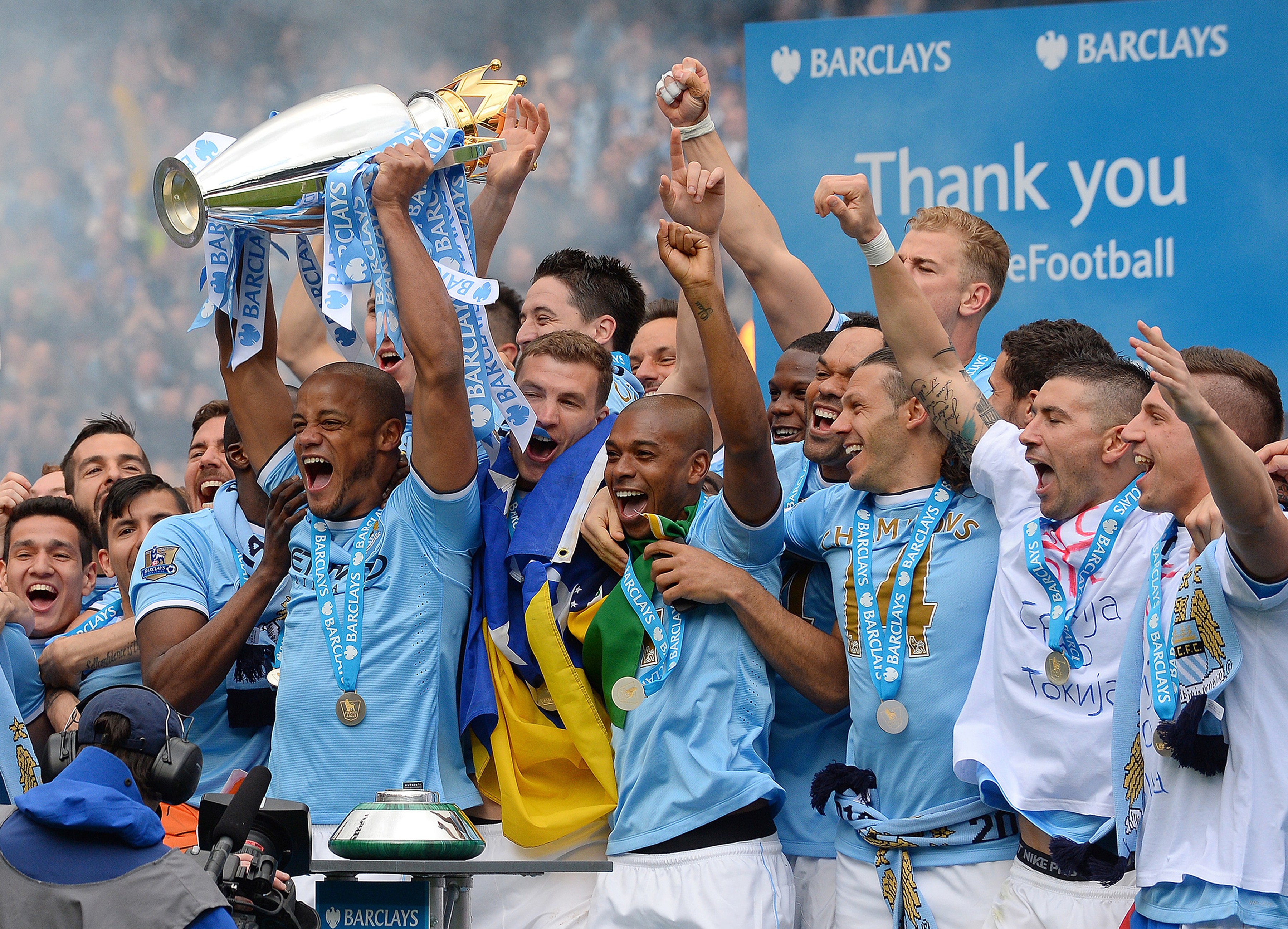 Manchester City's Belgian midfielder Vincent Kompany celebrates with the trophy after his team won the Premiership title following their victory in the English Premier League football match between Manchester City and West Ham United at the Etihad Stadium in Manchester on May 11, 2014. AFP PHOTO/ANDREW YATES
RESTRICTED TO EDITORIAL USE. No use with unauthorized audio, video, data, fixture lists, club/league logos or live services. Online in-match use limited to 45 images, no video emulation. No use in betting, games or single club/league/player publications. (Photo credit should read ANDREW YATES/AFP/Getty Images)
