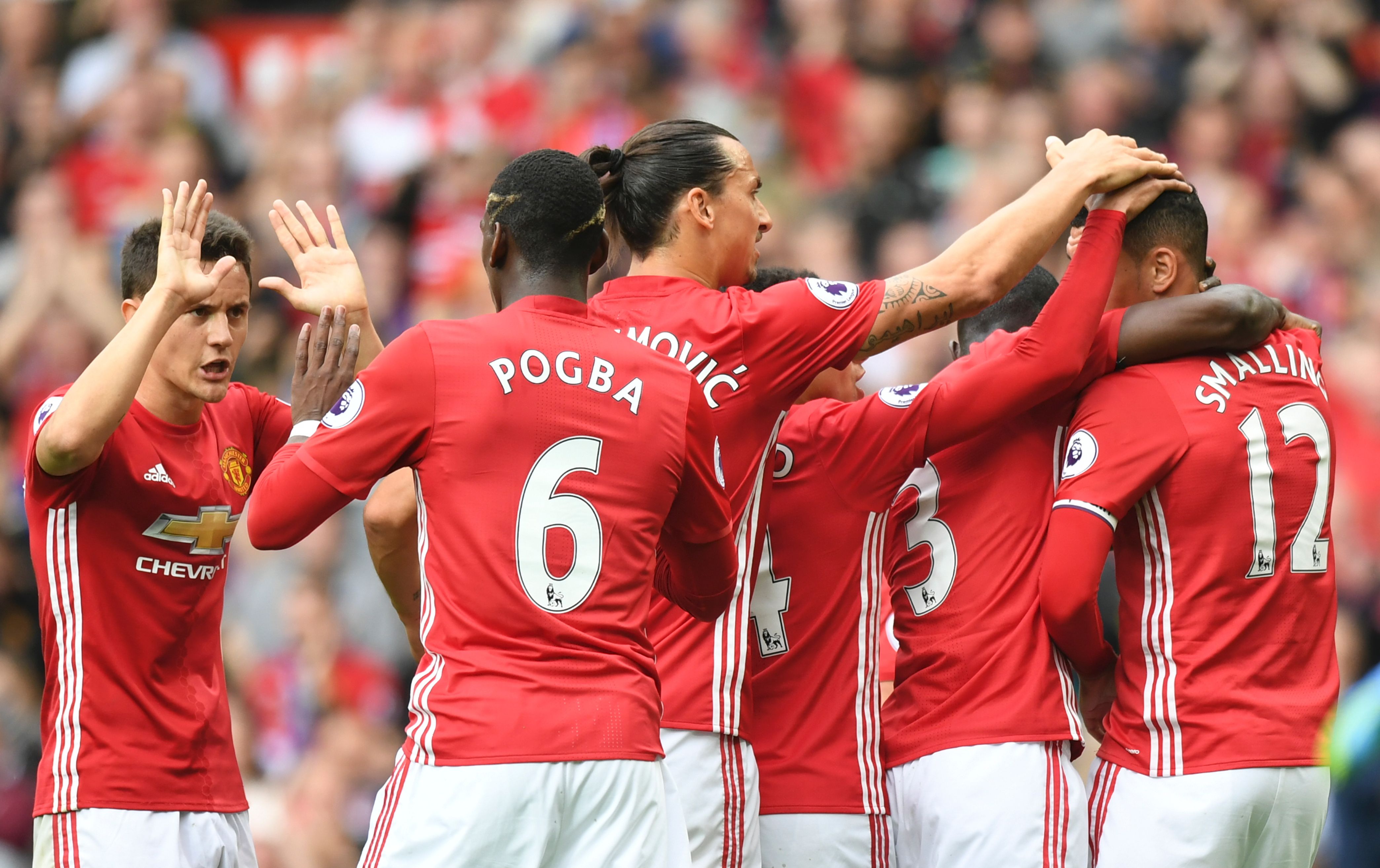 Manchester United's Spanish midfielder Ander Herrera (L), Manchester United's French midfielder Paul Pogba (2L) and Manchester United's Swedish striker Zlatan Ibrahimovic (C) celebrate the opening goal scored by Manchester United's English defender Chris Smalling (R) during the English Premier League football match between Manchester United and Leicester City at Old Trafford in Manchester, north west England, on September 24, 2016. / AFP / ANTHONY DEVLIN / RESTRICTED TO EDITORIAL USE. No use with unauthorized audio, video, data, fixture lists, club/league logos or 'live' services. Online in-match use limited to 75 images, no video emulation. No use in betting, games or single club/league/player publications. / (Photo credit should read ANTHONY DEVLIN/AFP/Getty Images)
