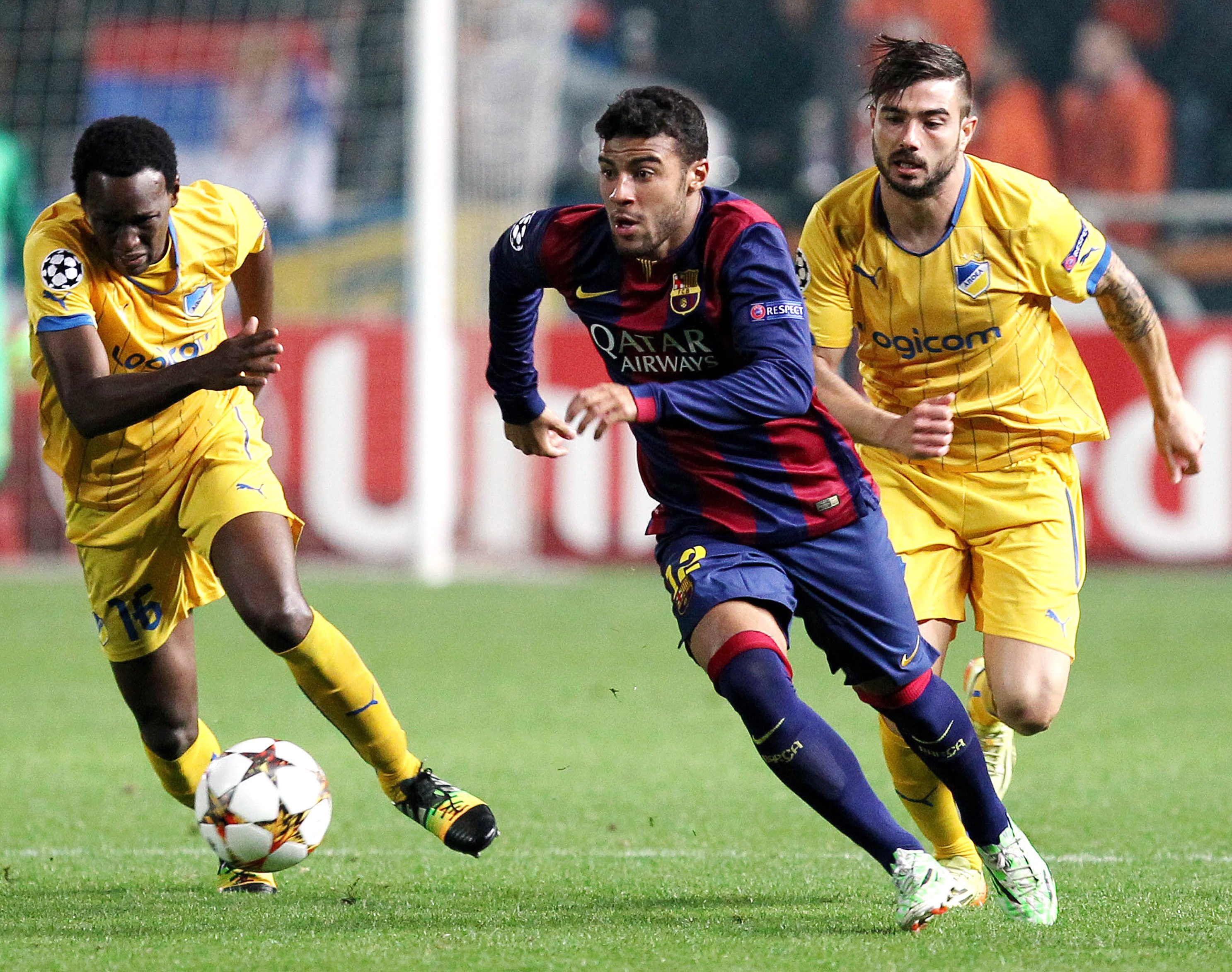 Barcelona's Brazilian midfielder Rafinha (C) vies for the ball against APOEL FC's Mario Sergio (R) and Brazilian midfielder Vinicius during their UEFA Champions League football match at the Neo GSP Stadium in the Cypriot capital, Nicosia, on November 25, 2014. AFP PHOTO/ SAKIS SAVVIDES (Photo credit should read SAKIS SAVVIDES/AFP/Getty Images)