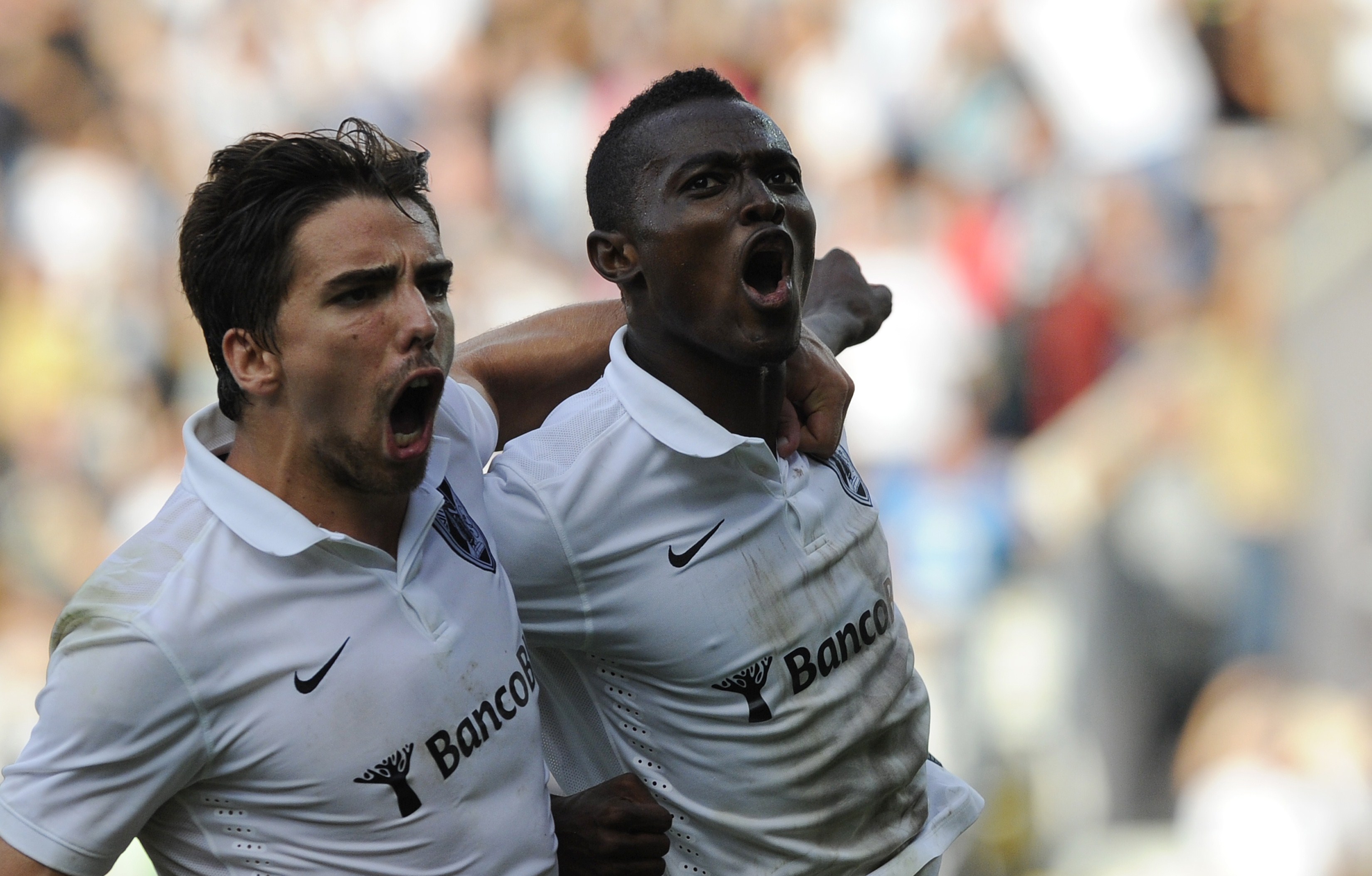 Vitoria SC's Ghanaian midfielder Bernard Mensah (R) celebrates with his teammate forward Tomane after scoring during the Portuguese league football match Vitoria SC vs FC Porto at the Afonso Henriques Stadium in Guimaraes on September 14, 2014. AFP PHOTO/ MIGUEL RIOPA (Photo credit should read MIGUEL RIOPA/AFP/Getty Images)