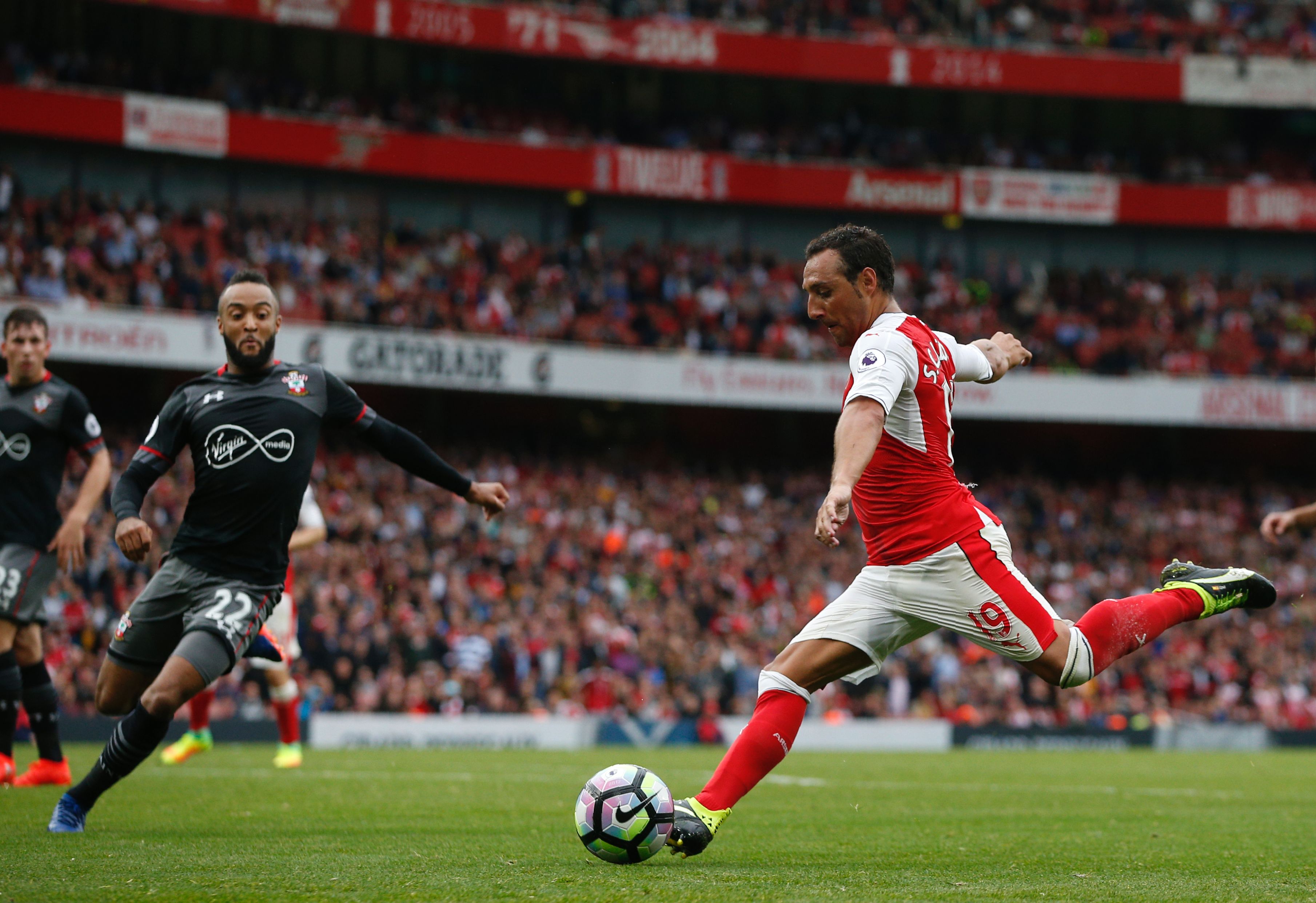 Arsenal's Spanish midfielder Santi Cazorla (R) crosses the ball during the English Premier League football match between Arsenal and Southampton at the Emirates Stadium in London on September 10, 2016. / AFP / Adrian DENNIS / RESTRICTED TO EDITORIAL USE. No use with unauthorized audio, video, data, fixture lists, club/league logos or 'live' services. Online in-match use limited to 75 images, no video emulation. No use in betting, games or single club/league/player publications. / (Photo credit should read ADRIAN DENNIS/AFP/Getty Images)