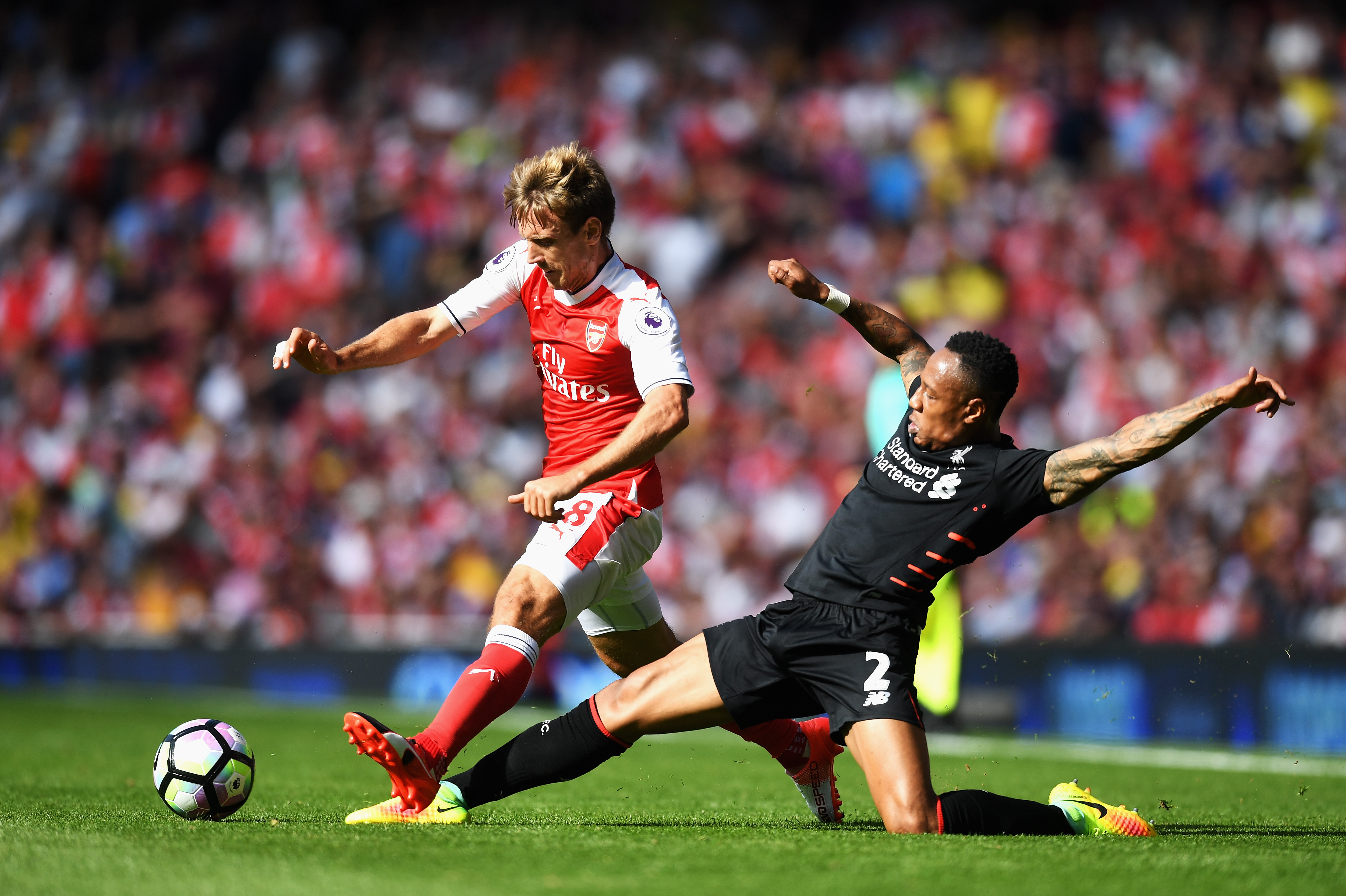 LONDON, ENGLAND - AUGUST 14: Nacho Monreal of Arsenal is tackled by Nathaniel Clyne of Liverpool during the Premier League match between Arsenal and Liverpool at Emirates Stadium on August 14, 2016 in London, England. (Photo by Michael Regan/Getty Images)
