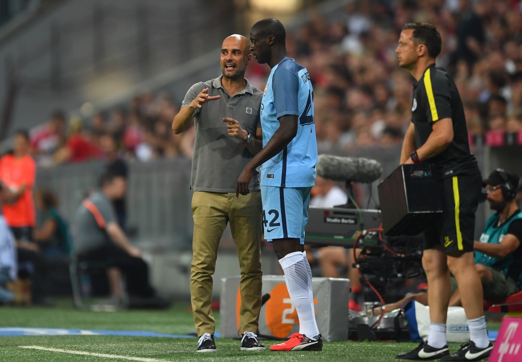 MUNICH, GERMANY - JULY 20: Pep Guardiola the manager of Manchester City speaks with substitute Yaya Toure of Manchester City during the pre season friendly match between Bayern Muenchen and Manchester City F.C at the Allianz Arena on July 20, 2016 in Munich, Germany. (Photo by Lennart Preiss/Bongarts/Getty Images)