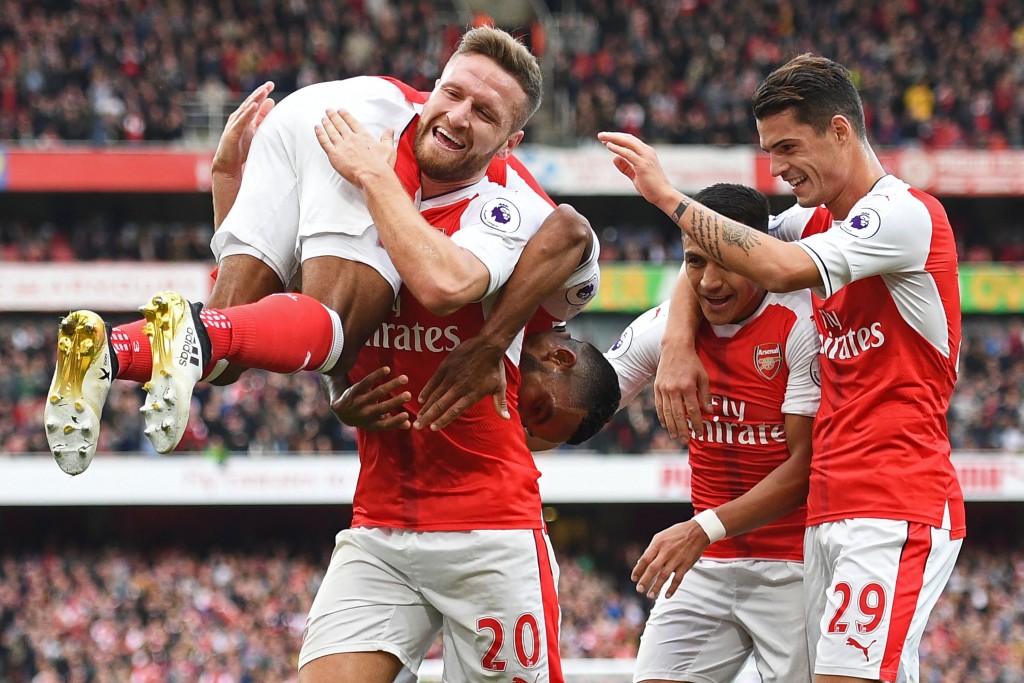 Arsenal's English midfielder Theo Walcott (L) celebrates with Arsenal's German defender Shkodran Mustafi (2nd L) Arsenal's Chilean striker Alexis Sanchez (2nd R) and Arsenal's Swiss midfielder Granit Xhaka (R) after scoring their second goal during the English Premier League football match between Arsenal and Swansea City at the Emirates Stadium in London on October 15, 2016.  Arsenal won the game 3-2. / AFP / Justin TALLIS / RESTRICTED TO EDITORIAL USE. No use with unauthorized audio, video, data, fixture lists, club/league logos or 'live' services. Online in-match use limited to 75 images, no video emulation. No use in betting, games or single club/league/player publications.  /         (Photo credit should read JUSTIN TALLIS/AFP/Getty Images)