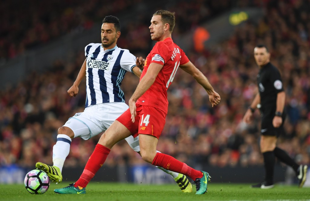 Liverpool's English midfielder Jordan Henderson (R) plays the ball in front of West Bromwich Albion's Belgian midfielder Nacer Chadli (L) during the English Premier League football match between Liverpool and West Bromwich Albion at Anfield in Liverpool, north west England on October 22, 2016. / AFP / PAUL ELLIS / RESTRICTED TO EDITORIAL USE. No use with unauthorized audio, video, data, fixture lists, club/league logos or 'live' services. Online in-match use limited to 75 images, no video emulation. No use in betting, games or single club/league/player publications. / (Photo credit should read PAUL ELLIS/AFP/Getty Images)