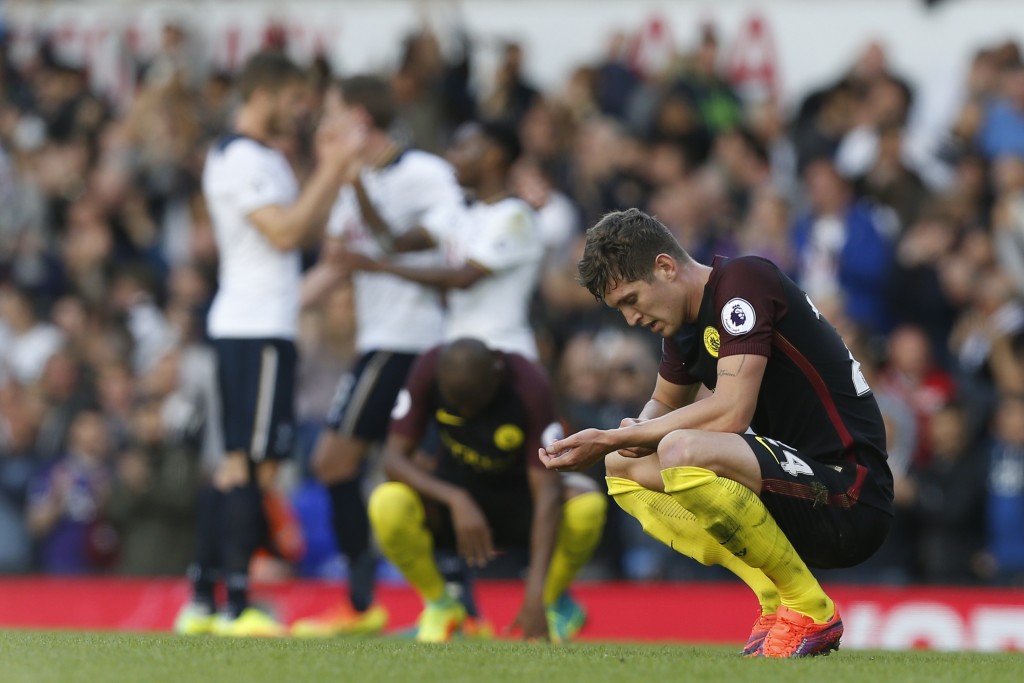Manchester City's English defender John Stones reacts on the final whistle as Tottenham player celebrate behind after the English Premier League football match between Tottenham Hotspur and Manchester City at White Hart Lane in London, on October 2, 2016. Tottenham won the game 2-0, Manchester City's first defeat of the season. / AFP / IKIMAGES / Ian KINGTON / RESTRICTED TO EDITORIAL USE. No use with unauthorized audio, video, data, fixture lists, club/league logos or 'live' services. Online in-match use limited to 75 images, no video emulation. No use in betting, games or single club/league/player publications. / (Photo credit should read IAN KINGTON/AFP/Getty Images)