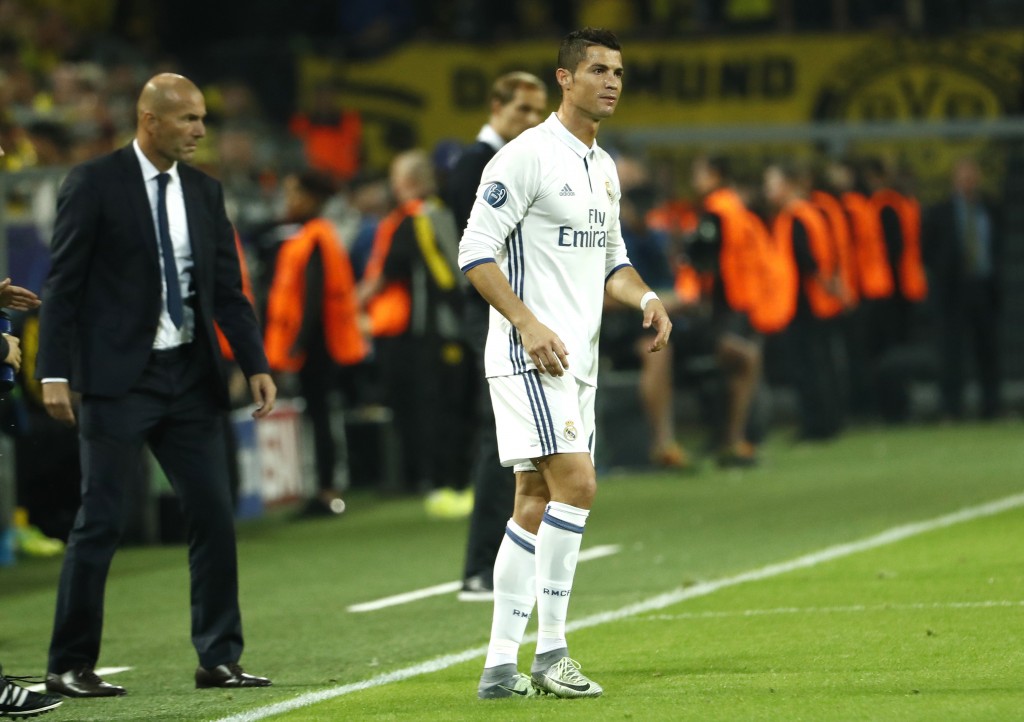 Real Madrid's French coach Zinedine Zidane (L) and Real Madrid's Portuguese forward Cristiano Ronaldo react during the UEFA Champions League first leg football match between Borussia Dortmund and Real Madrid at BVB stadium in Dortmund, on September 27, 2016. / AFP / Odd ANDERSEN (Photo credit should read ODD ANDERSEN/AFP/Getty Images)