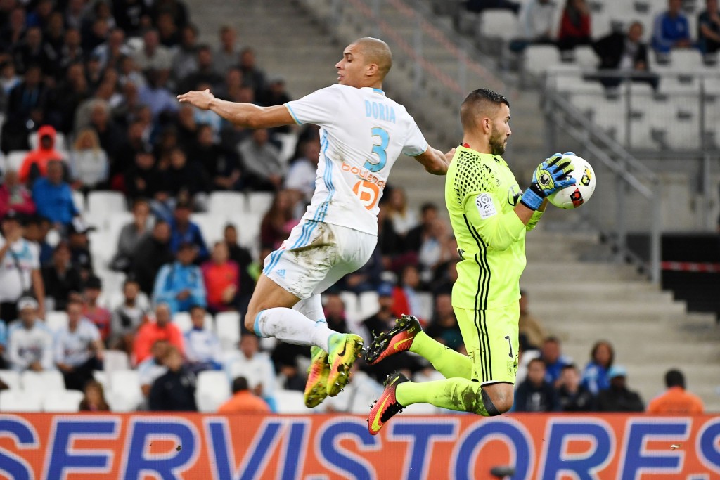 Olympique de Marseille's Brazilian defender Matheus 'Doria' Macedo (L) competes for the ball with Lyon's Portuguese goalkeeper Anthony Lopes during the French L1 football match Olympique of Marseille (OM) vs Lyon at the Velodrome stadium in Marseille on September 18, 2016. (Photo by Boris Horvat/AFP/Getty Images)