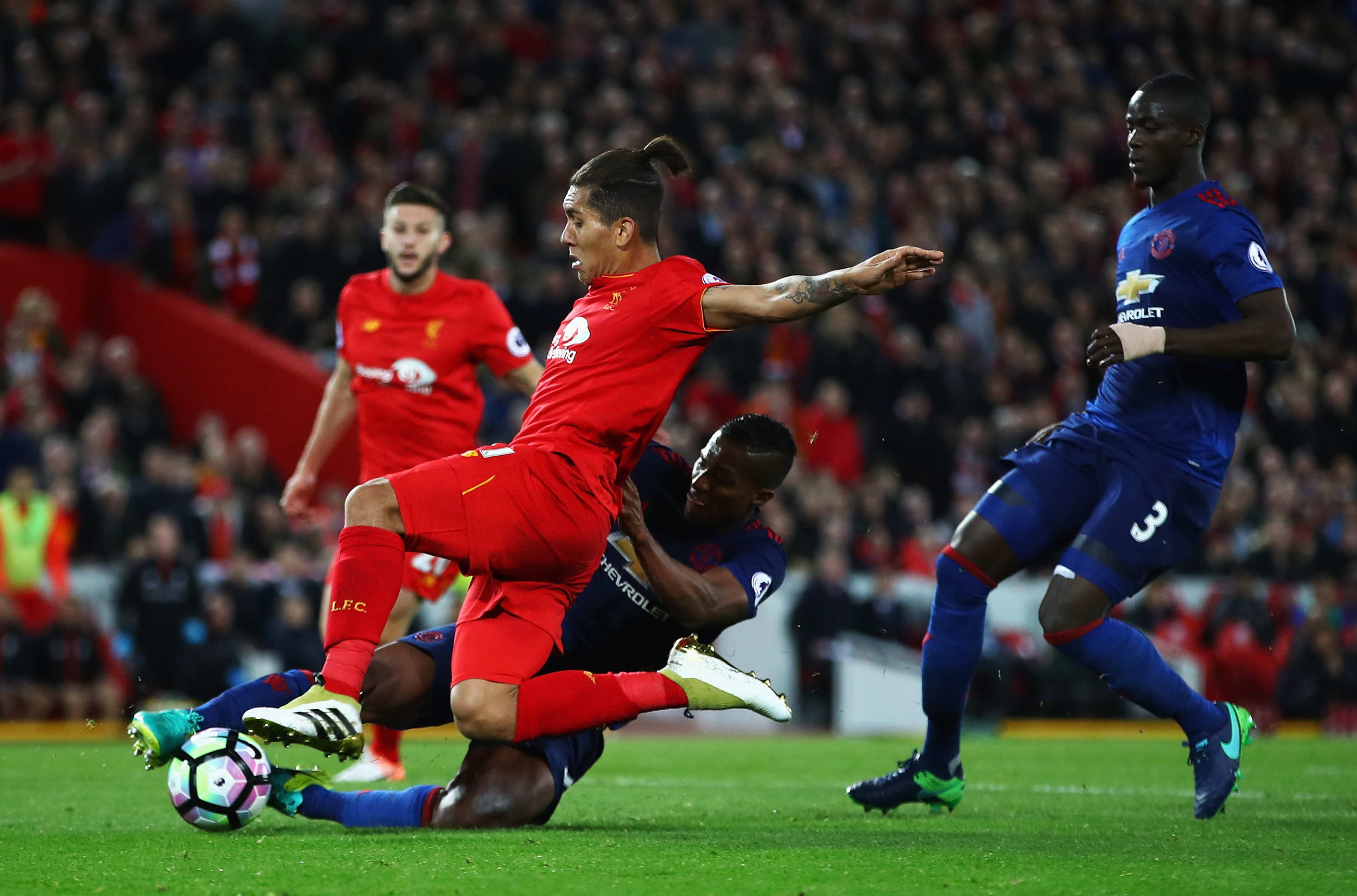 LIVERPOOL, ENGLAND - OCTOBER 17: Antonio Valencia of Manchester United tackles Roberto Firmino of Liverpool during the Premier League match between Liverpool and Manchester United at Anfield on October 17, 2016 in Liverpool, England. (Photo by Clive Brunskill/Getty Images)