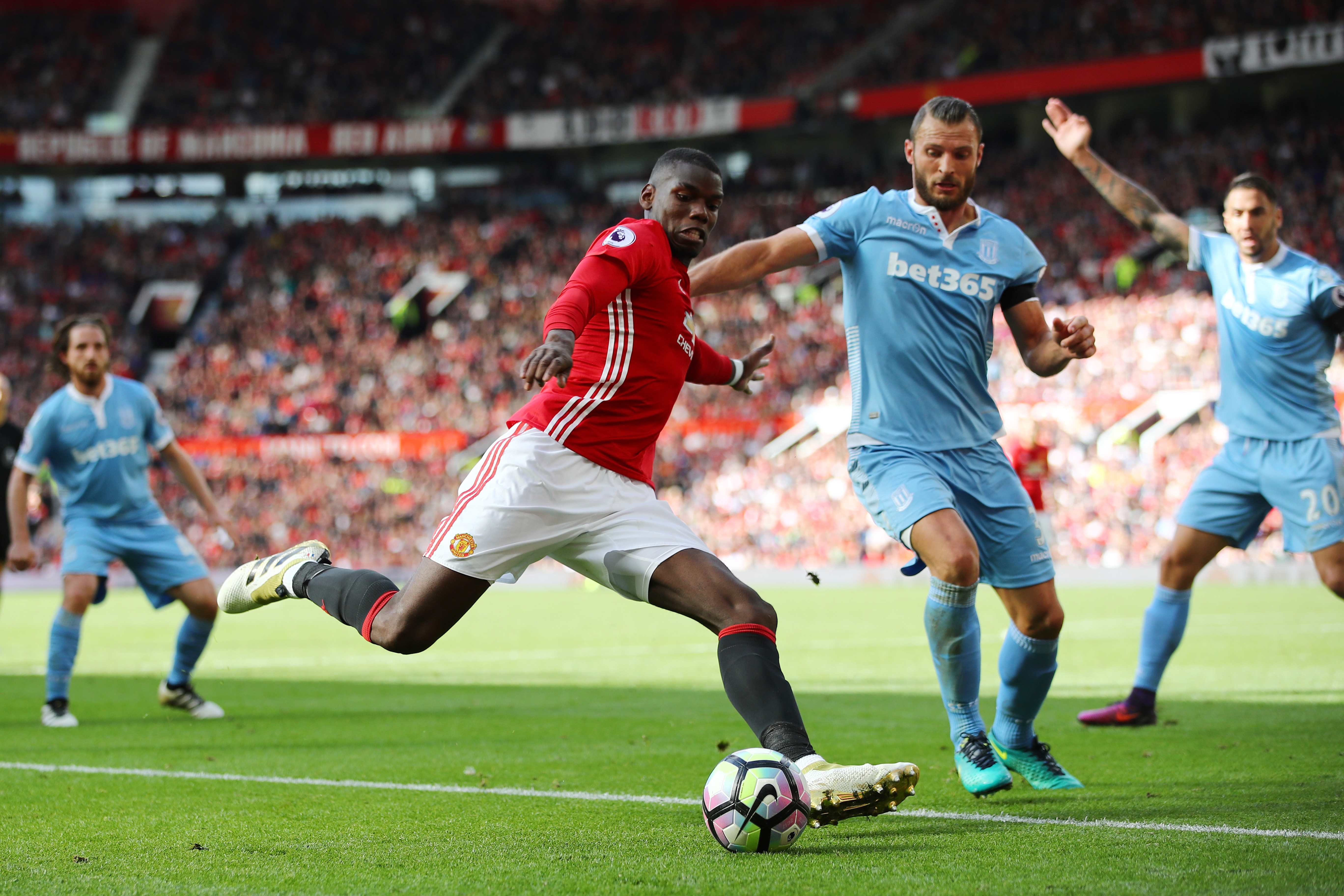 MANCHESTER, ENGLAND - OCTOBER 02:  Paul Pogba of Manchester United (L) shoots while Erik Pieters of Stoke City (R) attempts to block the shot during the Premier League match between Manchester United and Stoke City at Old Trafford on October 2, 2016 in Manchester, England.  (Photo by Clive Brunskill/Getty Images)