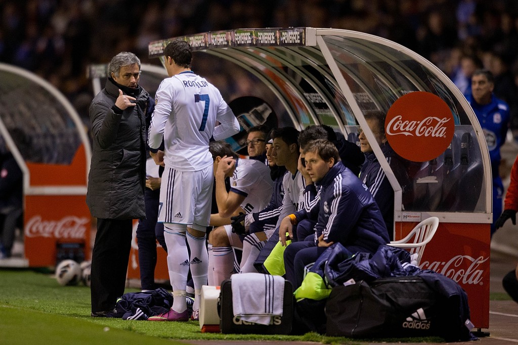 LA CORUNA, SPAIN - FEBRUARY 23: Head coach Jose Mourinho of Real Madrid CF gives instructions to Cristiano Ronaldo (2ndl) and Mezut Ozil (3dL) on the desk during the La Liga match between RC Deportivo La Coruna and Real Madrid CF at Riazor Stadium on February 23, 2013 in La Coruna, Spain. (Photo by Gonzalo Arroyo Moreno/Getty Images)