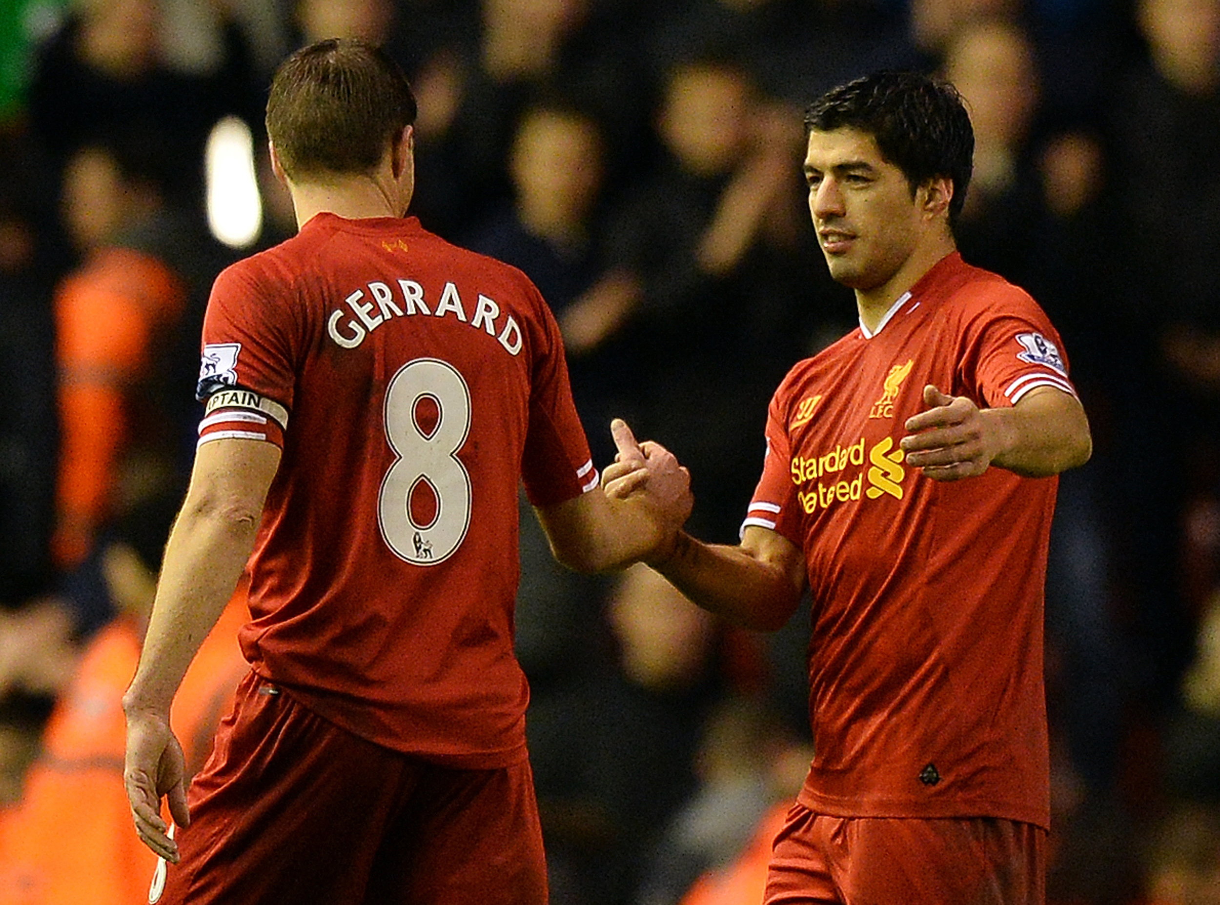 Liverpool's Uruguayan striker Luis Suarez (R) celebrates with Liverpool's English midfielder Steven Gerrard (L) after the English Premier League football match between Liverpool and Everton at the Anfield stadium in Liverpool, northwest England, on January 28, 2014. Liverpool won 4-0.  AFP PHOTO / PAUL ELLIS

RESTRICTED TO EDITORIAL USE. No use with unauthorized audio, video, data, fixture lists, club/league logos or live services. Online in-match use limited to 45 images, no video emulation. No use in betting, games or single club/league/player publications.        (Photo credit should read PAUL ELLIS/AFP/Getty Images)