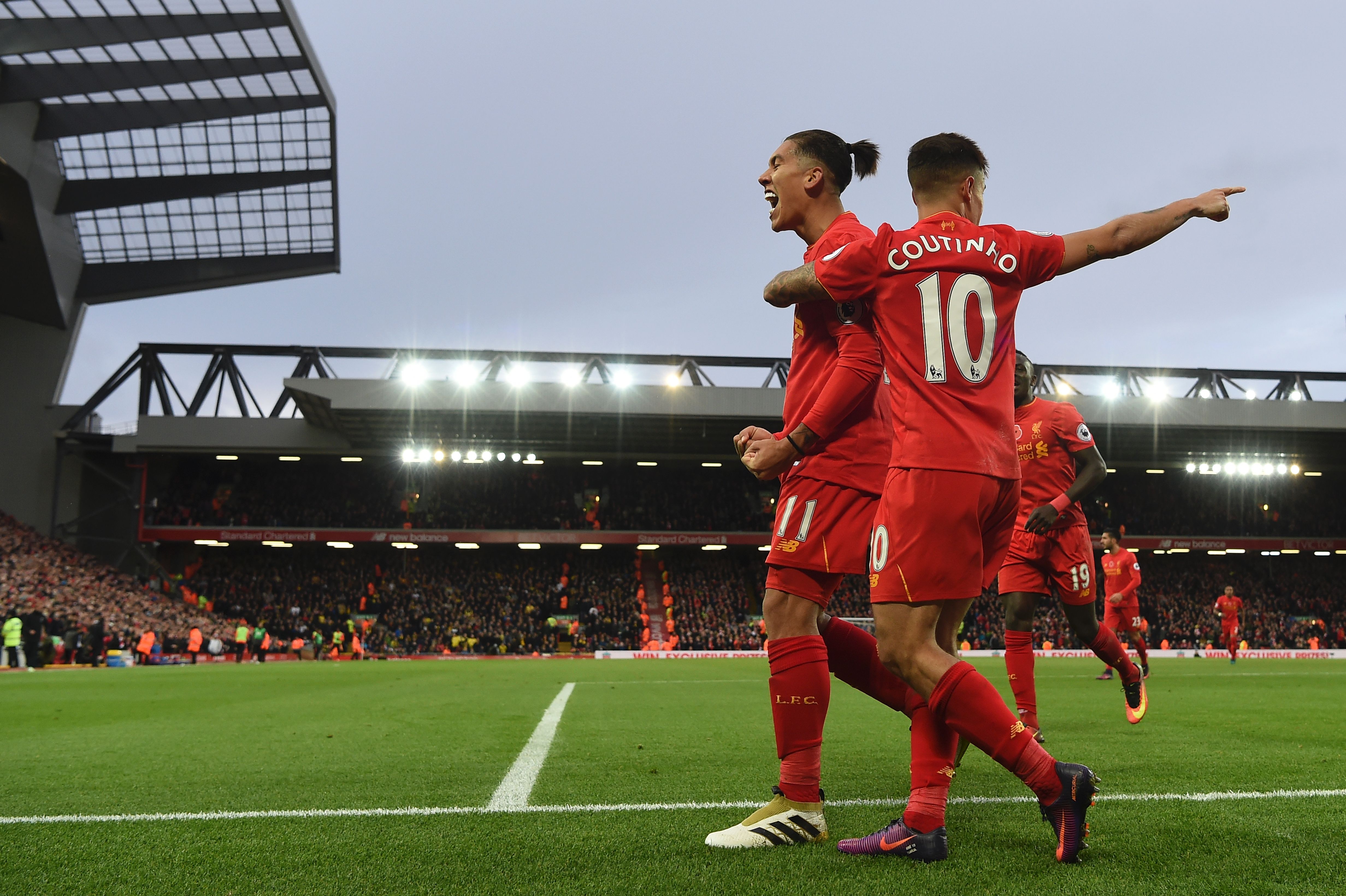 Liverpool's Brazilian midfielder Roberto Firmino (L) celebrates scoring his team's fourth goal Liverpool's Brazilian midfielder Philippe Coutinho with during the English Premier League football match between Liverpool and Watford at Anfield in Liverpool, north west England on November 6, 2016. / AFP / PAUL ELLIS / RESTRICTED TO EDITORIAL USE. No use with unauthorized audio, video, data, fixture lists, club/league logos or 'live' services. Online in-match use limited to 75 images, no video emulation. No use in betting, games or single club/league/player publications. / (Photo credit should read PAUL ELLIS/AFP/Getty Images)
