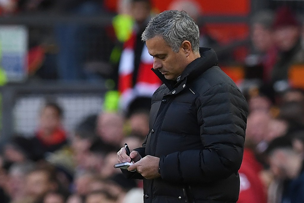 Manchester United's Portuguese manager Jose Mourinho makes notes as he watches his players from the touchline during the English Premier League football match between Manchester United and Arsenal at Old Trafford in Manchester, north west England, on November 19, 2016. / AFP / PAUL ELLIS / RESTRICTED TO EDITORIAL USE. No use with unauthorized audio, video, data, fixture lists, club/league logos or 'live' services. Online in-match use limited to 75 images, no video emulation. No use in betting, games or single club/league/player publications. / (Photo credit should read PAUL ELLIS/AFP/Getty Images)