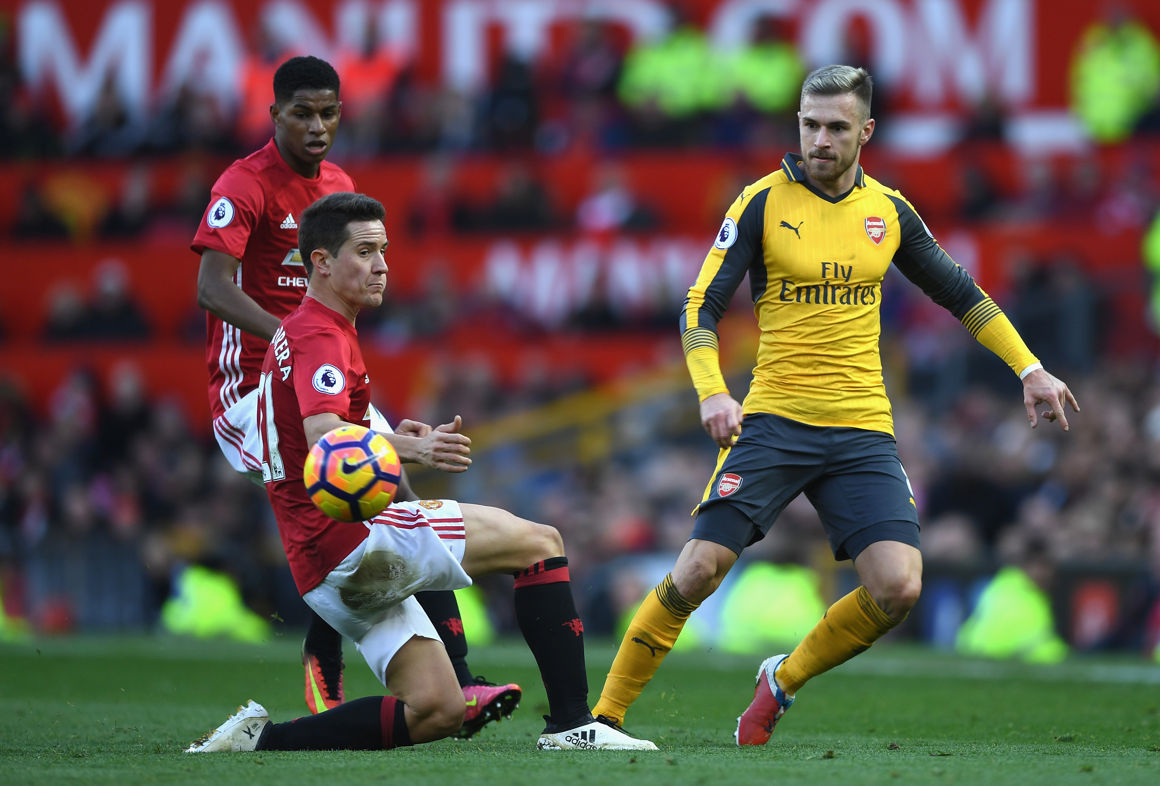 MANCHESTER, ENGLAND - NOVEMBER 19: Aaron Ramsey of Arsenal (R) passes the ball past Ander Herrera of Manchester United (L) during the Premier League match between Manchester United and Arsenal at Old Trafford on November 19, 2016 in Manchester, England. (Photo by Shaun Botterill/Getty Images)