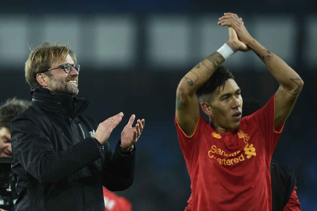 Liverpool's German manager Jurgen Klopp (L) and Liverpool's Brazilian midfielder Roberto Firmino applaud the fans following the English Premier League football match between Everton and Liverpool at Goodison Park in Liverpool, north west England on December 19, 2016. Liverpool won the match 1-0. / AFP / Oli SCARFF / RESTRICTED TO EDITORIAL USE. No use with unauthorized audio, video, data, fixture lists, club/league logos or 'live' services. Online in-match use limited to 75 images, no video emulation. No use in betting, games or single club/league/player publications. / (Photo credit should read OLI SCARFF/AFP/Getty Images)