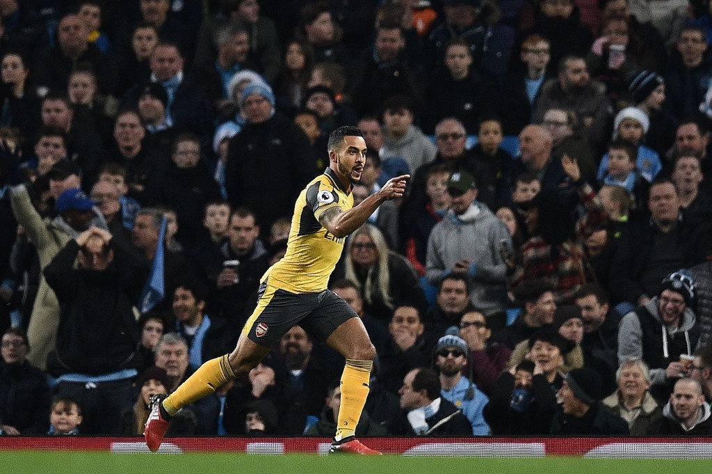 Arsenal's English midfielder Theo Walcott (L) celebrates scoring his team's first goal during the English Premier League football match between Manchester City and Arsenal at the Etihad Stadium in Manchester, north west England, on December 18, 2016. / AFP / Oli SCARFF / RESTRICTED TO EDITORIAL USE. No use with unauthorized audio, video, data, fixture lists, club/league logos or 'live' services. Online in-match use limited to 75 images, no video emulation. No use in betting, games or single club/league/player publications. / (Photo credit should read OLI SCARFF/AFP/Getty Images)
