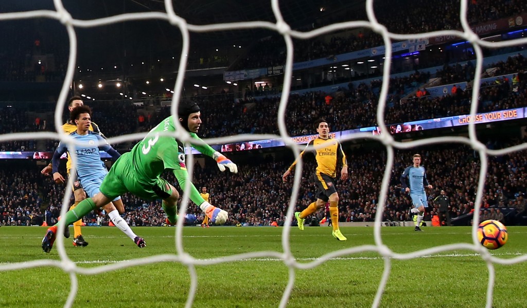 MANCHESTER, ENGLAND - DECEMBER 18: Leroy Sane of Manchester City (L) scores his sides first goal past Petr Cech of Arsenal (C) during the Premier League match between Manchester City and Arsenal at the Etihad Stadium on December 18, 2016 in Manchester, England. (Photo by Clive Brunskill/Getty Images)