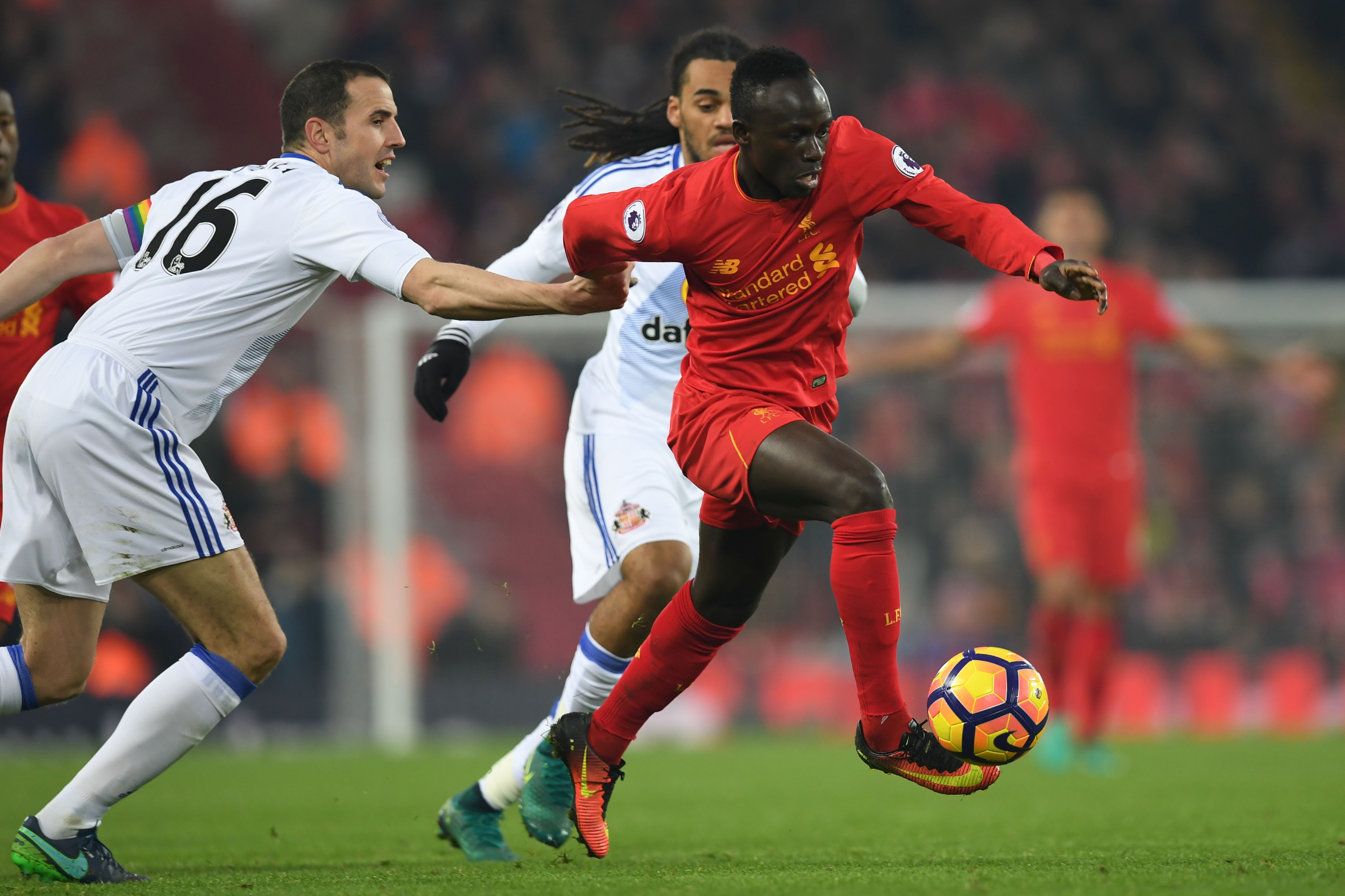 Liverpool's Senegalese midfielder Sadio Mane (R) tries to dribble away from Sunderland's Irish defender John O'Shea (L) during the English Premier League football match between Liverpool and Sunderland at Anfield in Liverpool, north west England on November 26, 2016. / AFP / Paul ELLIS / RESTRICTED TO EDITORIAL USE. No use with unauthorized audio, video, data, fixture lists, club/league logos or 'live' services. Online in-match use limited to 75 images, no video emulation. No use in betting, games or single club/league/player publications. / (Photo credit should read PAUL ELLIS/AFP/Getty Images)