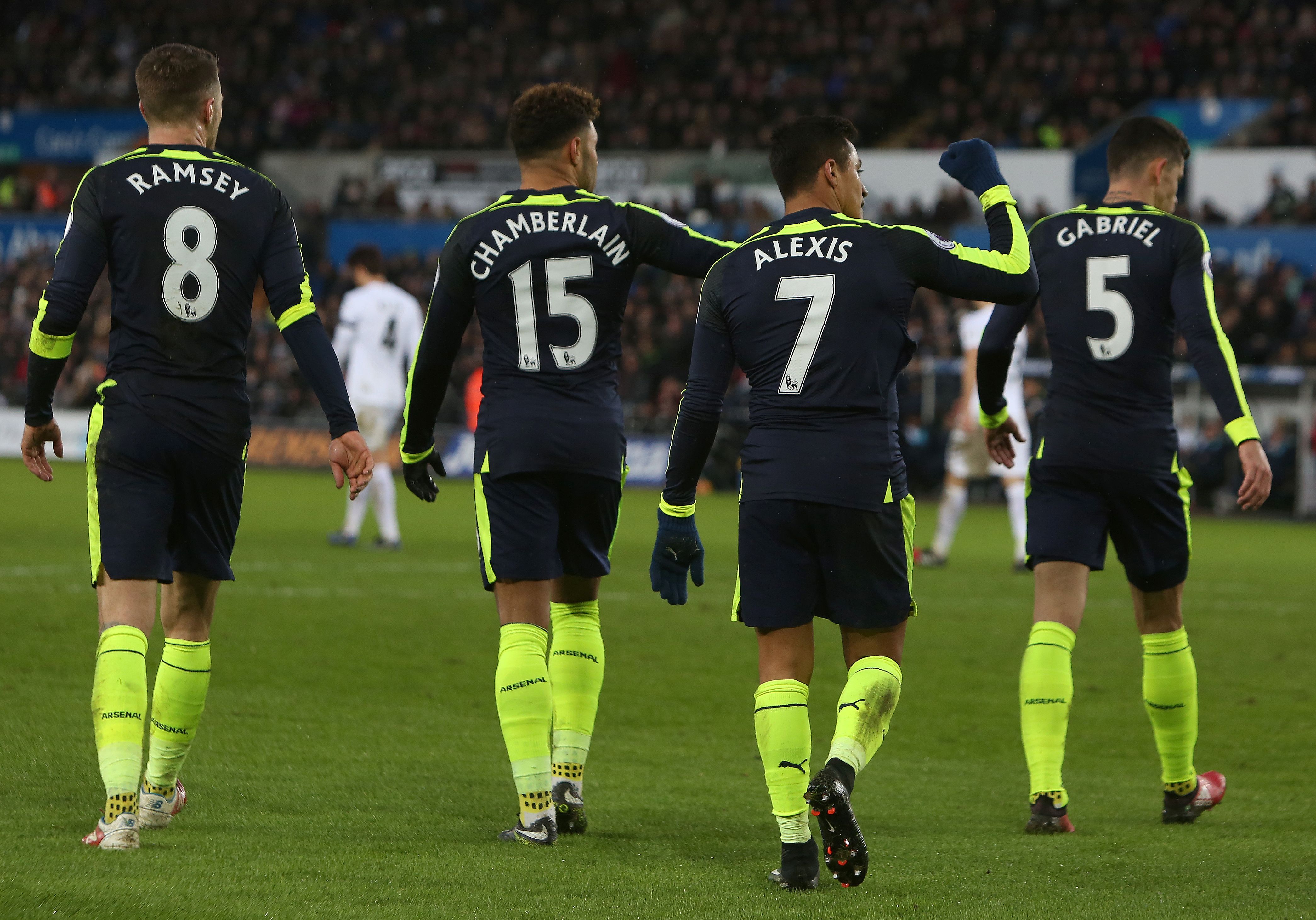Arsenal's Chilean striker Alexis Sanchez (2R) celebrates scoring his team's fourth goal during the English Premier League football match between Swansea City and Arsenal at The Liberty Stadium in Swansea, south Wales on January 14, 2017. / AFP / Geoff CADDICK / RESTRICTED TO EDITORIAL USE. No use with unauthorized audio, video, data, fixture lists, club/league logos or 'live' services. Online in-match use limited to 75 images, no video emulation. No use in betting, games or single club/league/player publications. / (Photo credit should read GEOFF CADDICK/AFP/Getty Images)