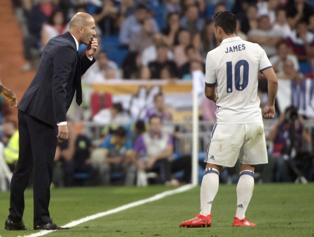 Real Madrid's French coach Zinedine Zidane (L) talks with Real Madrid's Colombian midfielder James Rodriguez during the Spanish league football match Real Madrid CF vs Villarreal CF at the Santiago Bernabeu stadium in Madrid on September 21, 2016. (Photo by Curto De La Torre/AFP/Getty Images)