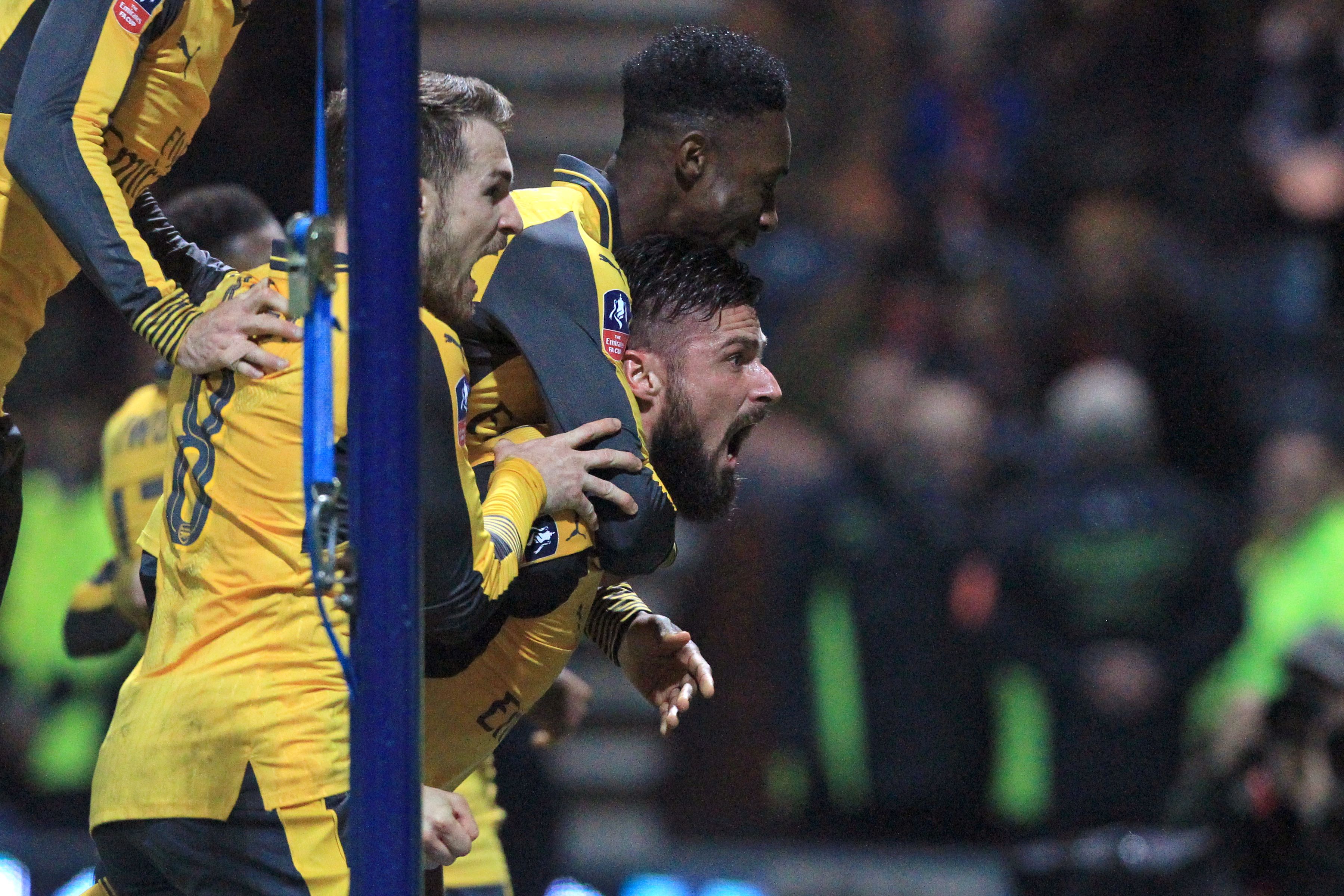 Arsenal's French striker Olivier Giroud (R) celebrates with Arsenal's English striker Danny Welbeck and Arsenal's Welsh midfielder Aaron Ramsey (L) after scoring their second goal during the English FA Cup third round football match between Preston North End and Arsenal at Deepdale in north west England on January 7, 2017.
Arsenal won the game 2-1. / AFP / Lindsey PARNABY / RESTRICTED TO EDITORIAL USE. No use with unauthorized audio, video, data, fixture lists, club/league logos or 'live' services. Online in-match use limited to 75 images, no video emulation. No use in betting, games or single club/league/player publications. / (Photo credit should read LINDSEY PARNABY/AFP/Getty Images)