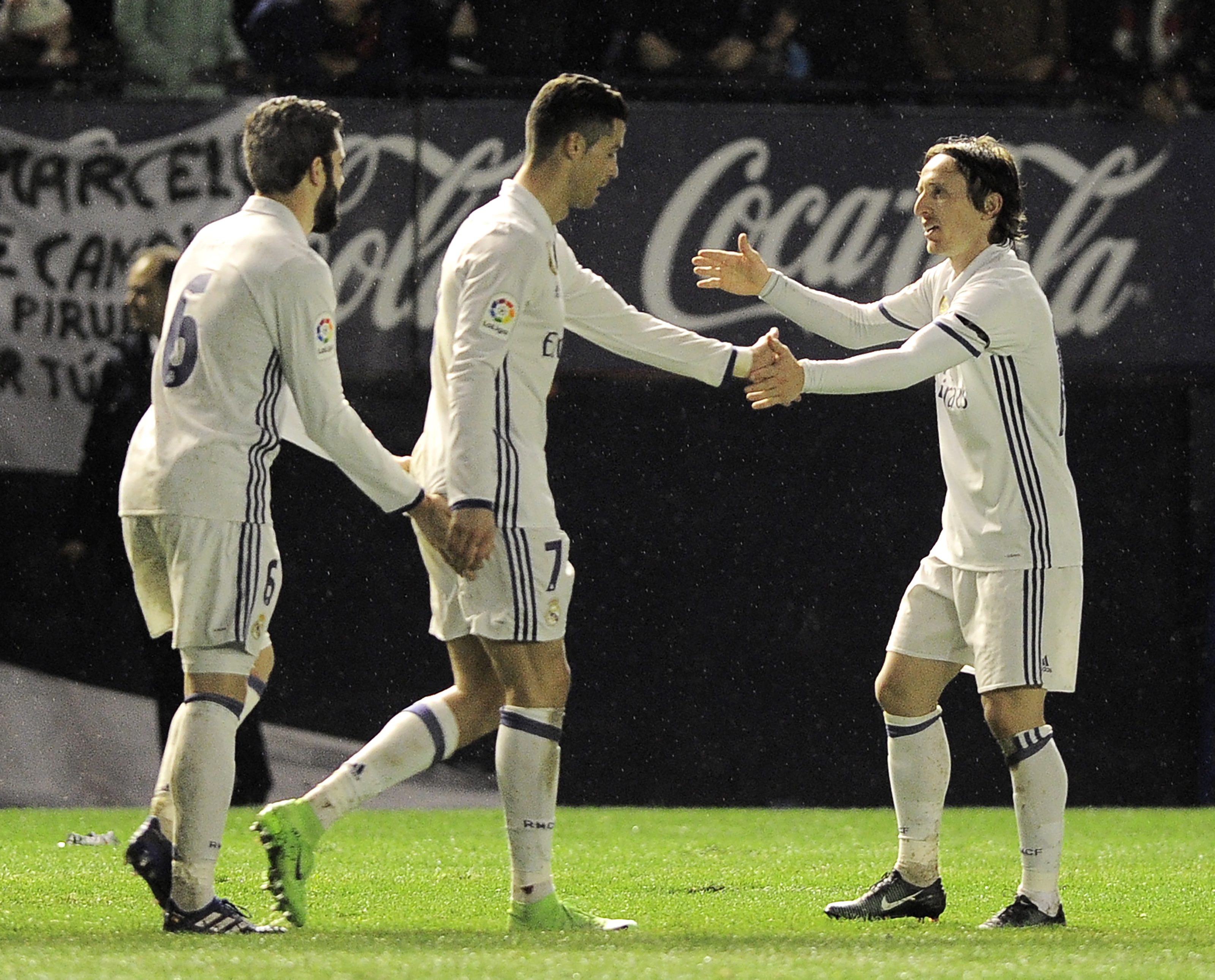(L-R) Real Madrid's defender Nacho Fernandez, Portuguese forward Cristiano Ronaldo and Croatian midfielder Luka Modric celebrate after forward Lucas Vazquez scoring his team's third goal during the Spanish league football match CA Osasuna vs Real Madrid CF at El Sadar stadium in Pamplona on February 11, 2017. / AFP / ANDER GILLENEA (Photo credit should read ANDER GILLENEA/AFP/Getty Images)