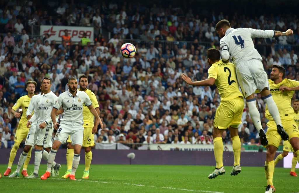 Real Madrid's defender Sergio Ramos (R) heads the ball to score a goal during the Spanish league football match Real Madrid CF vs Villarreal CF at the Santiago Bernabeu stadium in Madrid on September 21, 2016. / AFP / GERARD JULIEN (Photo credit should read GERARD JULIEN/AFP/Getty Images)