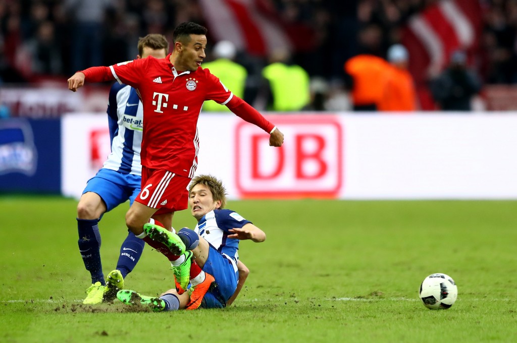 BERLIN, GERMANY - FEBRUARY 18: Genki Haraguchi (R) of Berlin and Thiago of Muenchen battle for the ball during the Bundesliga match between Hertha BSC and Bayern Muenchen at Olympiastadion on February 18, 2017 in Berlin, Germany. (Photo by Martin Rose/Bongarts/Getty Images)