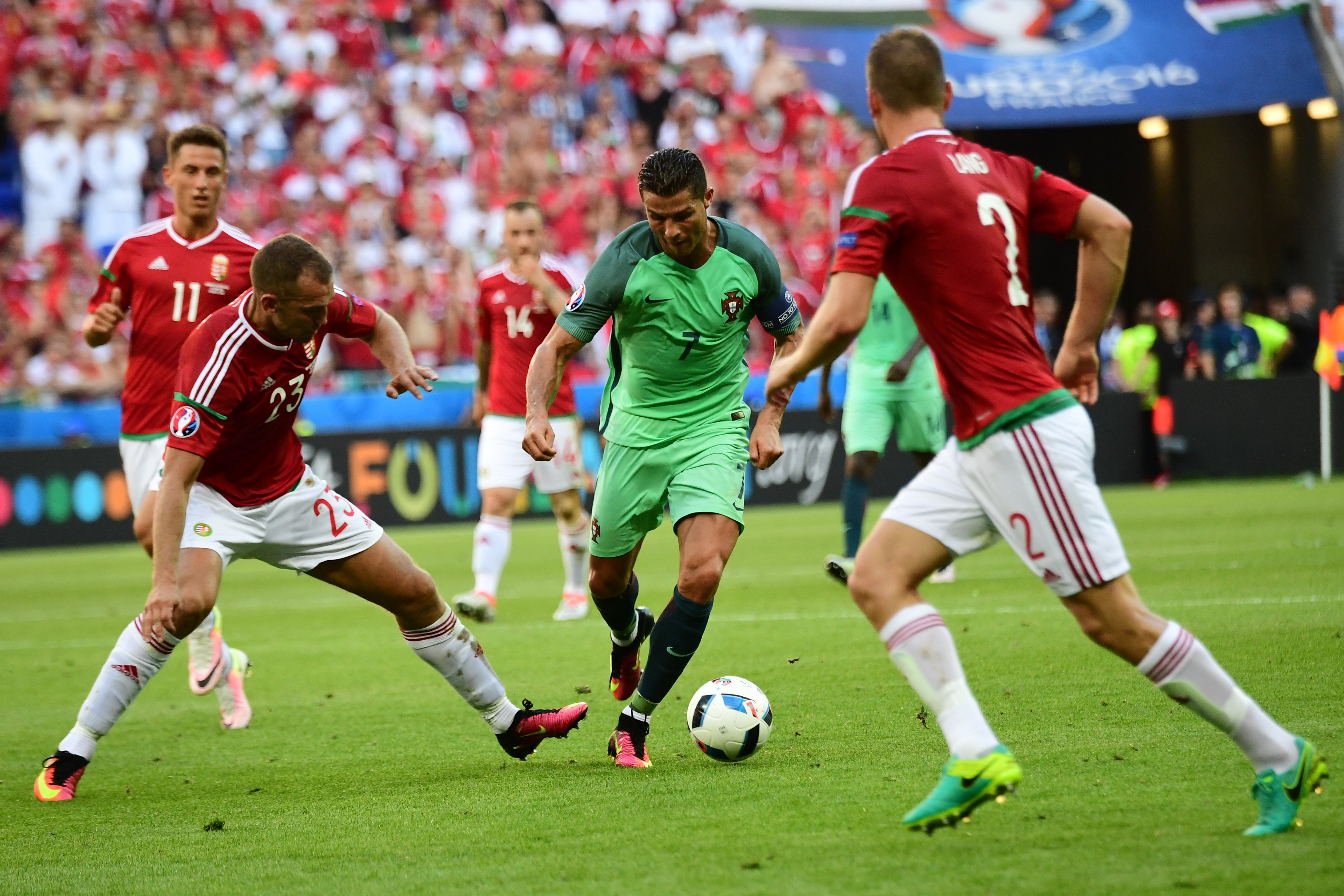 Portugal's forward Cristiano Ronaldo (C) vies with Hungary's defender Roland Juhasz during the Euro 2016 group F football match between Hungary and Portugal at the Parc Olympique Lyonnais stadium in Decines-Charpieu, near Lyon, on June 22, 2016. / AFP / ATTILA KISBENEDEK (Photo credit should read ATTILA KISBENEDEK/AFP/Getty Images)