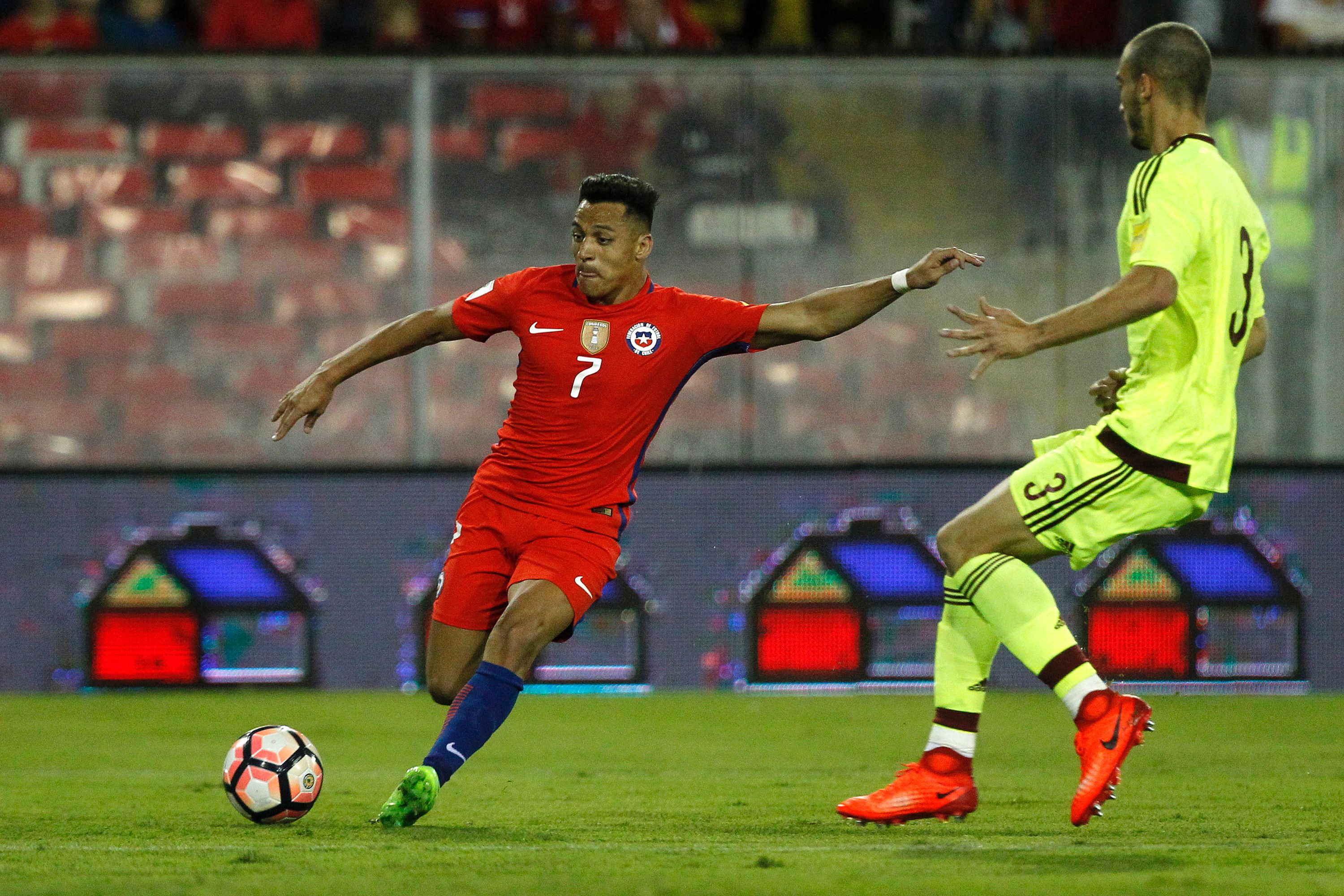 Chile's forward Alexis Sanchez (L) prepares to kick the ball next to Venezuela's defender Mike Villanueva during their 2018 FIFA World Cup qualifier football match in Santiago, Chile on March 28, 2017. / AFP PHOTO / Claudio Reyes (Photo credit should read CLAUDIO REYES/AFP/Getty Images)