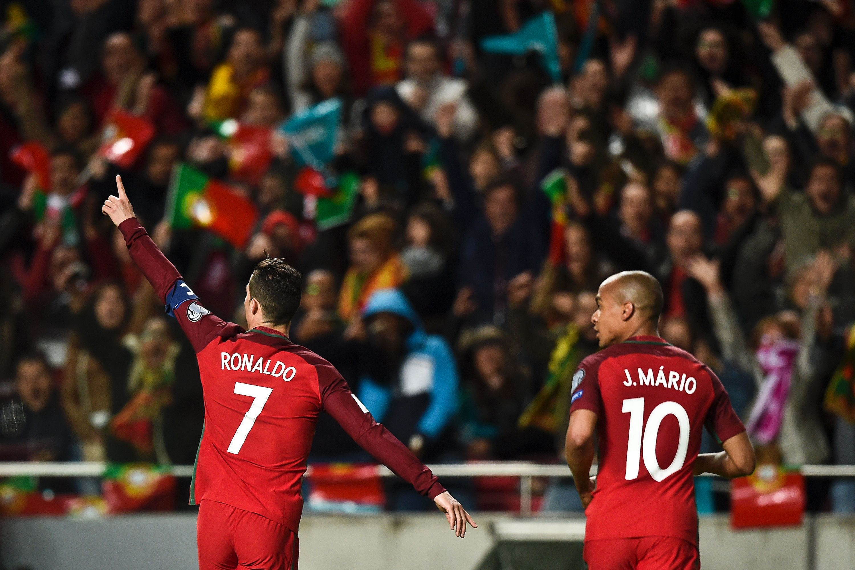 Portugal's forward Cristiano Ronaldo (L) celebrates after scoring during the WC 2018 group B football qualifing match Portugal vs Hungary at the Luz stadium in Lisbon on March 25, 2017. / AFP PHOTO / PATRICIA DE MELO MOREIRA (Photo credit should read PATRICIA DE MELO MOREIRA/AFP/Getty Images)