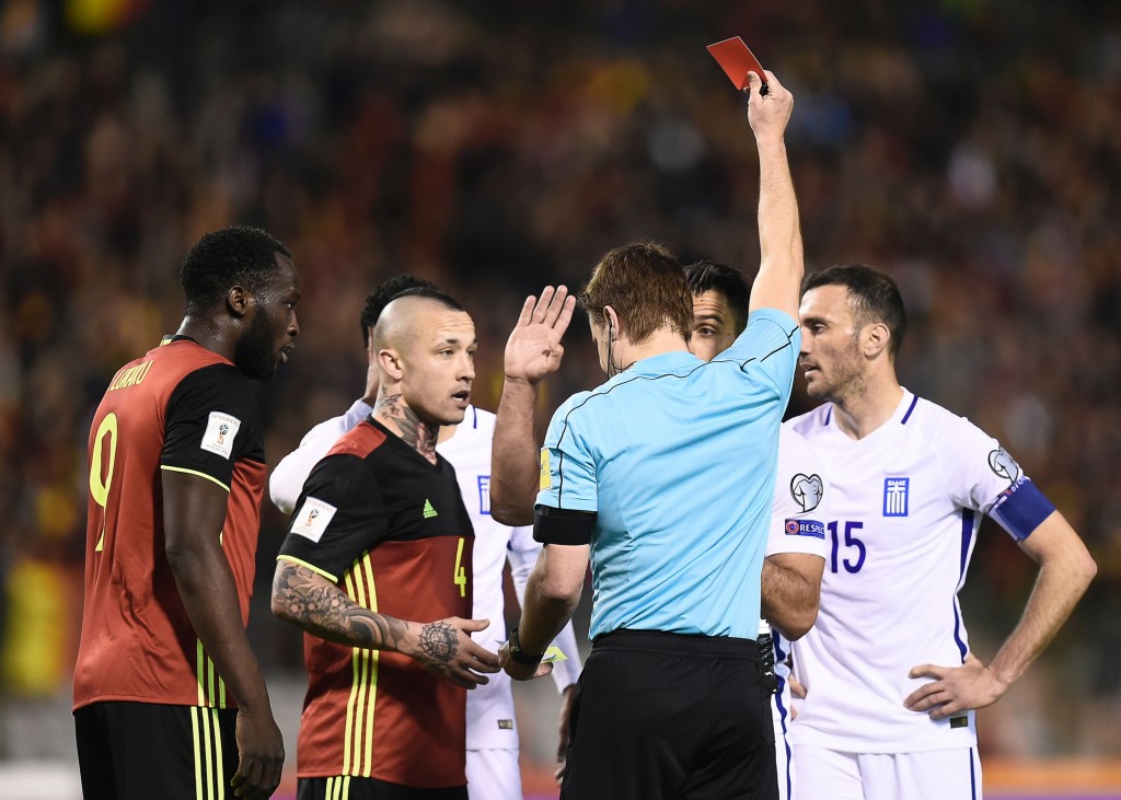 Greece's Giorgos Tzavellas (2nd R) receives a red card from German referee Felix Brych during the FIFA World Cup 2018 qualification football match between Belgium and Greece, at the King Baudouin Stadium, on March 25, 2017 in Brussels. / AFP PHOTO / JOHN THYS (Photo credit should read JOHN THYS/AFP/Getty Images)