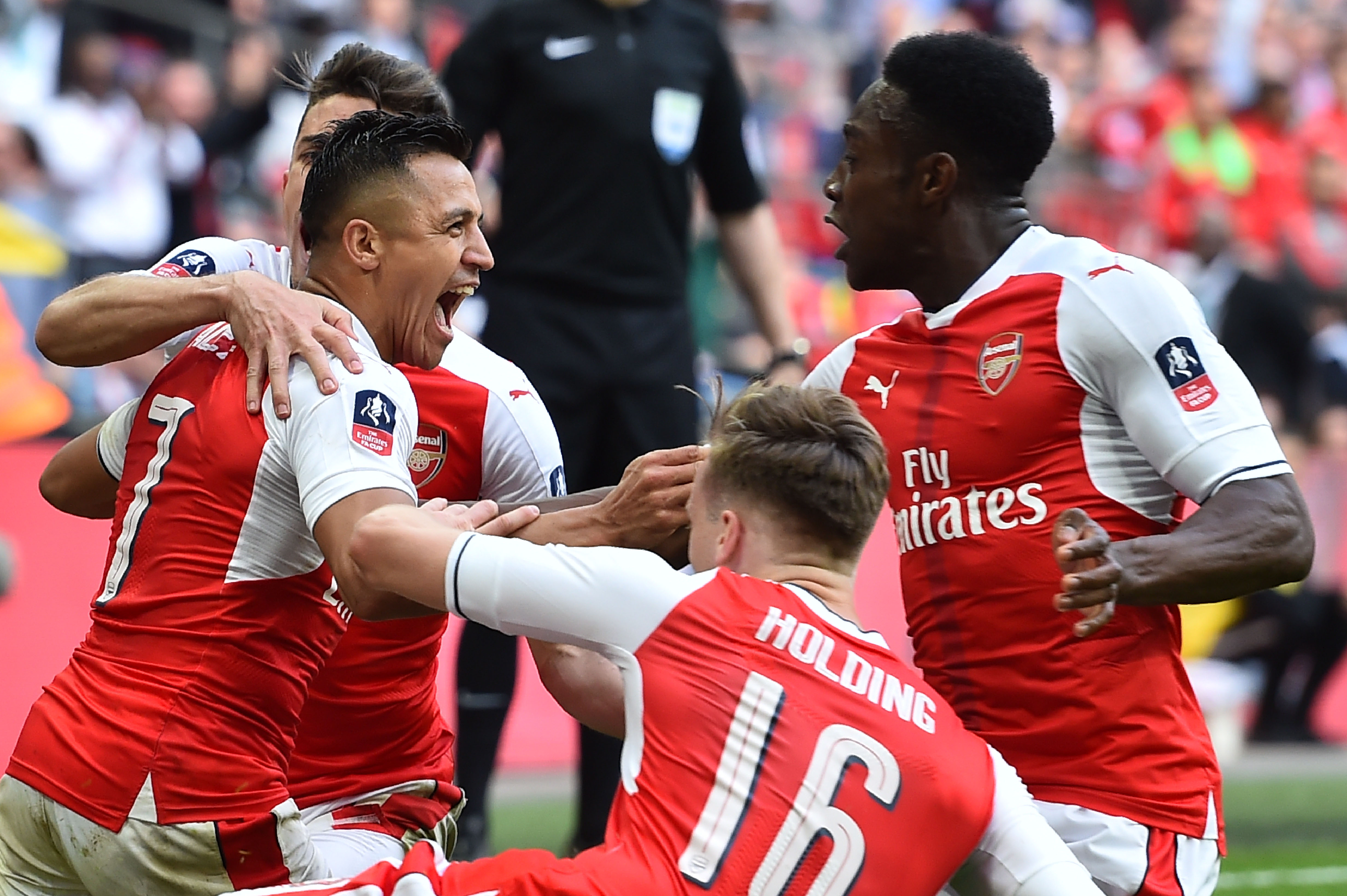 Arsenal's Chilean striker Alexis Sanchez (L) celebrates scoring the second goal with teammates during the FA Cup semi-final football match between Arsenal and Manchester City at Wembley stadium in London on April 23, 2017. / AFP PHOTO / Glyn KIRK / NOT FOR MARKETING OR ADVERTISING USE / RESTRICTED TO EDITORIAL USE
(Photo credit should read GLYN KIRK/AFP/Getty Images)