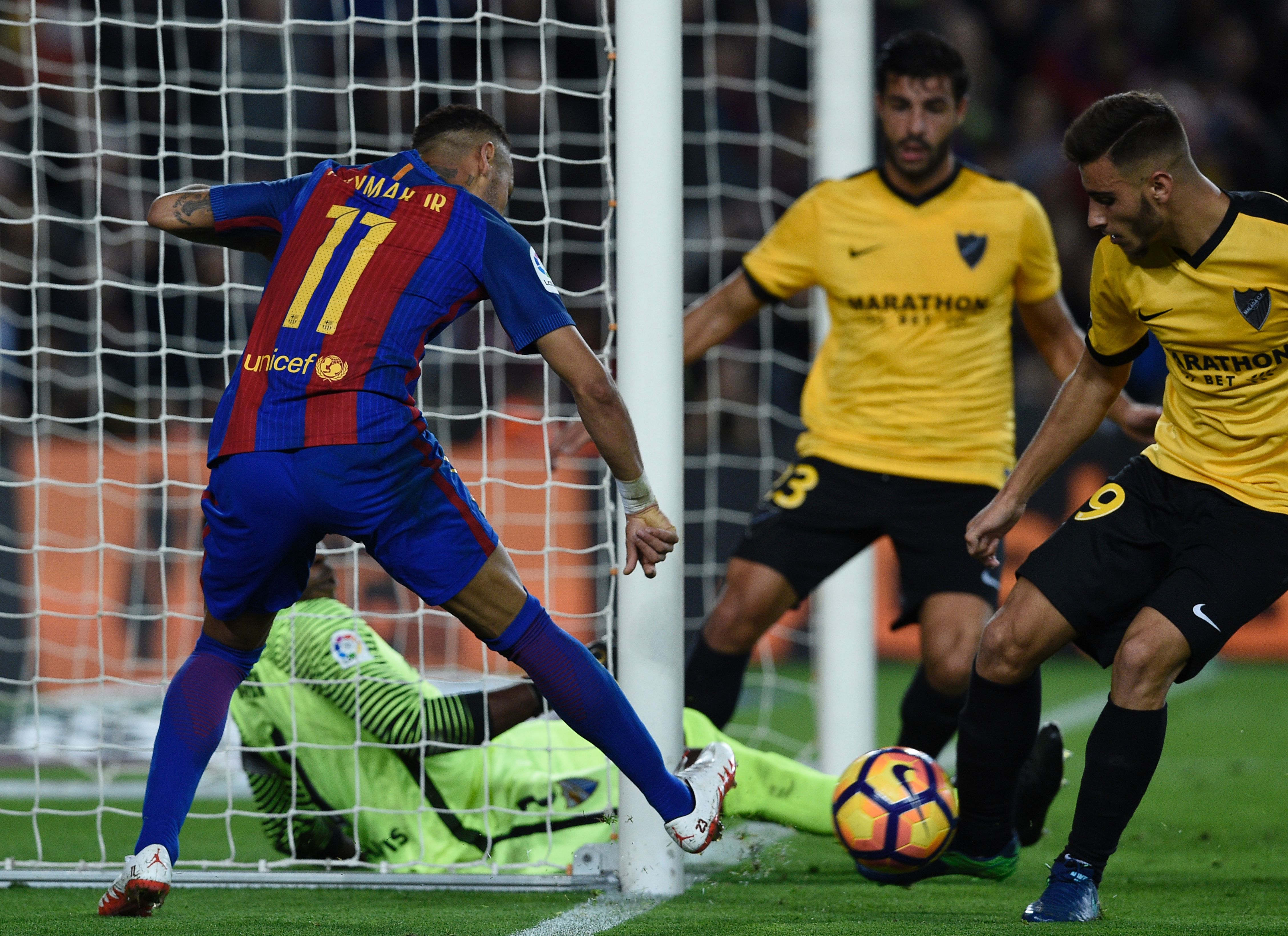 Barcelona's Brazilian forward Neymar (L) vies with Malaga's Brazilian forward Charles during the Spanish league football match FC Barcelona vs Malaga CF at the Camp Nou stadium in Barcelona, on November 19, 2016. / AFP / LLUIS GENE (Photo credit should read LLUIS GENE/AFP/Getty Images)